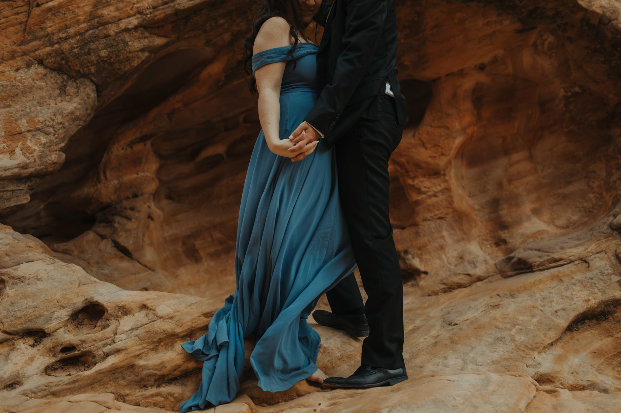Shoulders down of couple in desert wearing formal clothes