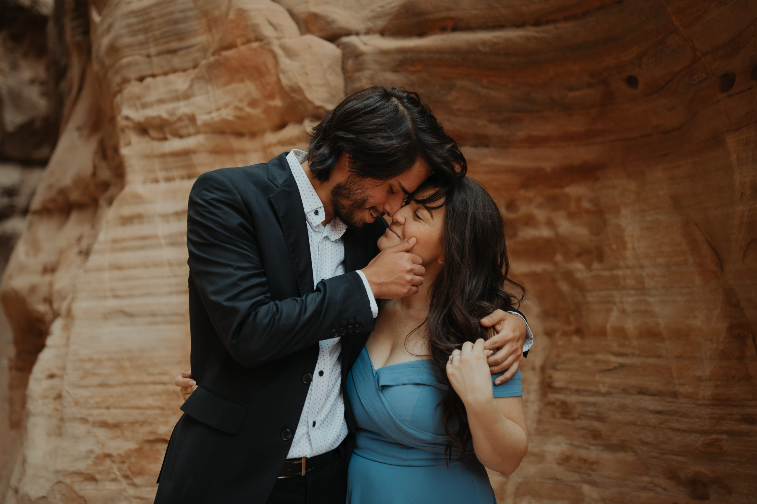 Couple kissing in canyon wearing formal attire