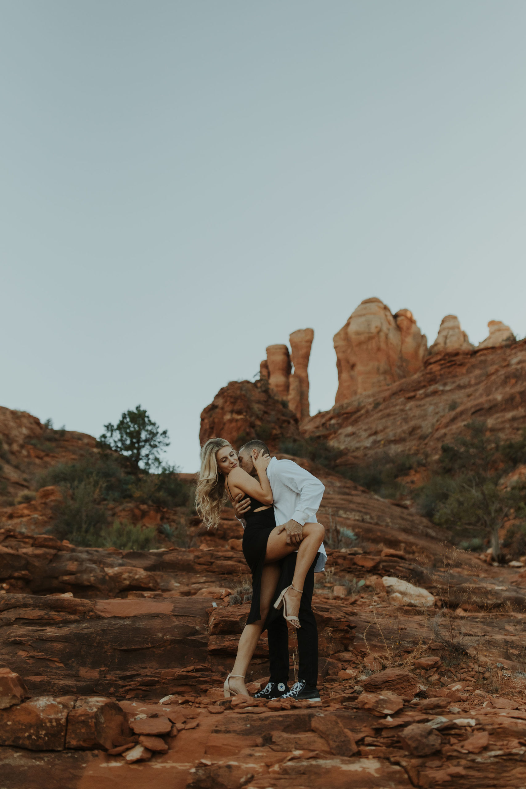 Couple standing in front of Cathedral Rock in Sedona for engagement photos