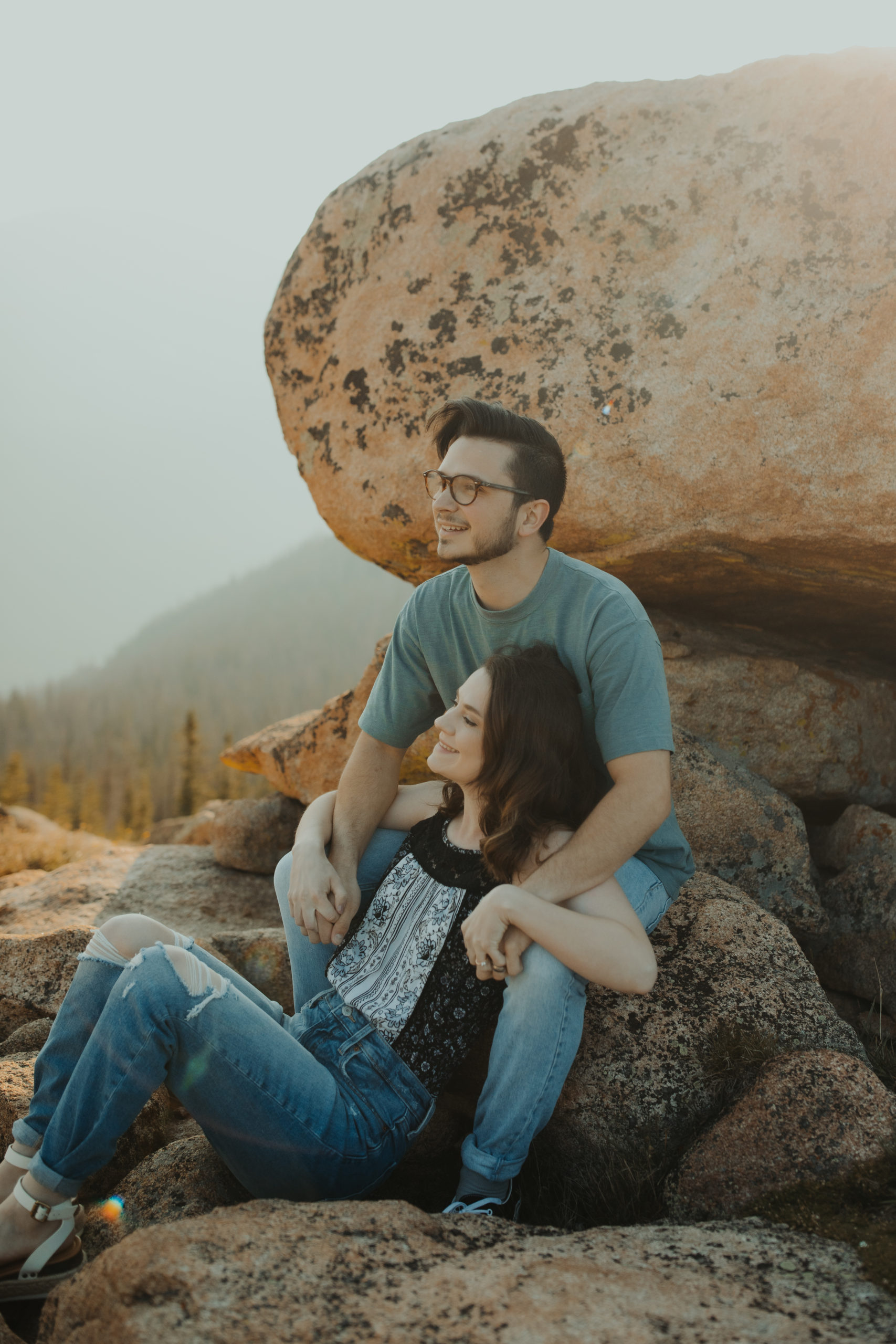 Couple all cuddled up in casual clothes in the rocky mountains