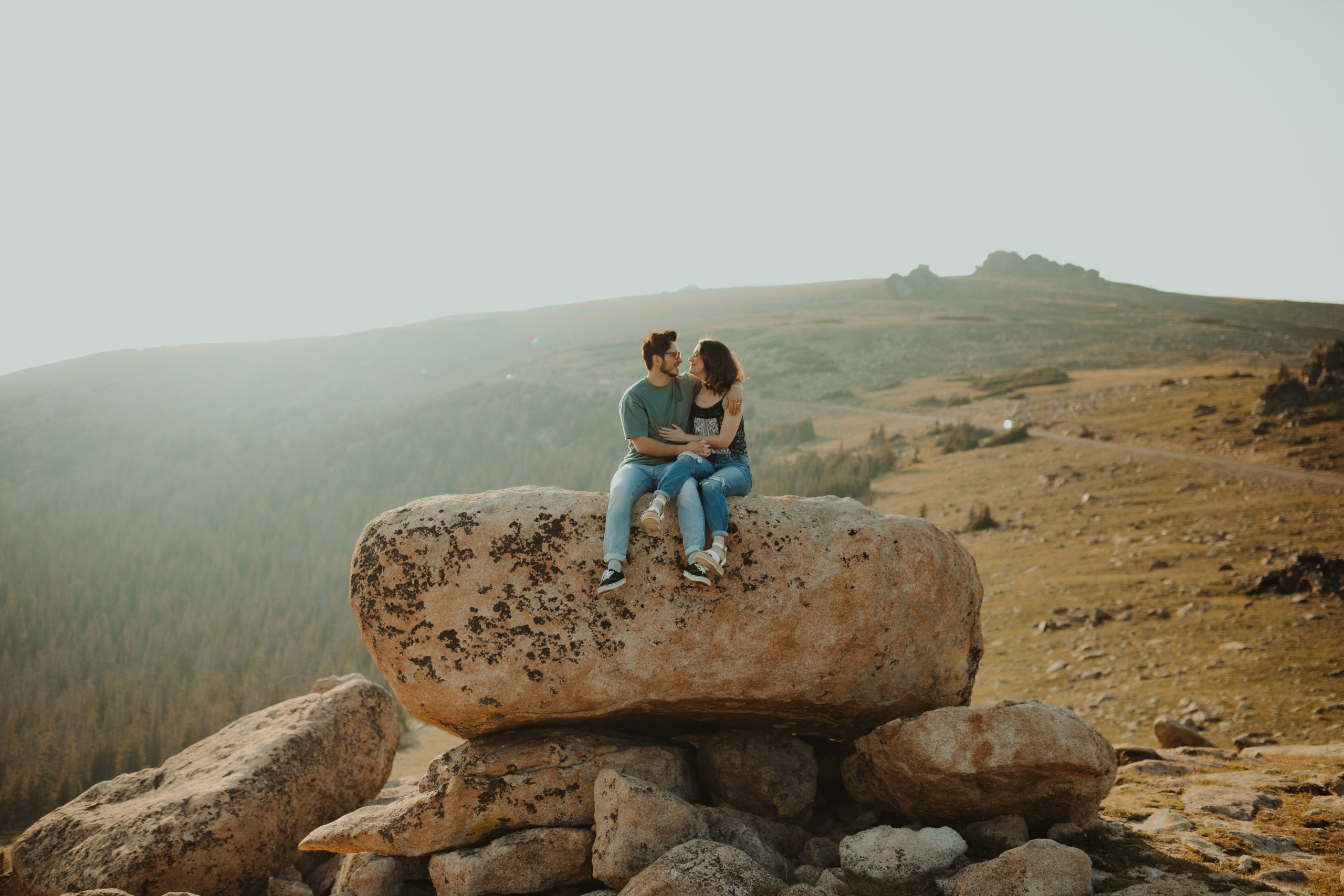 Couple sitting on top of a rock in the Colorado Rocky Mountains