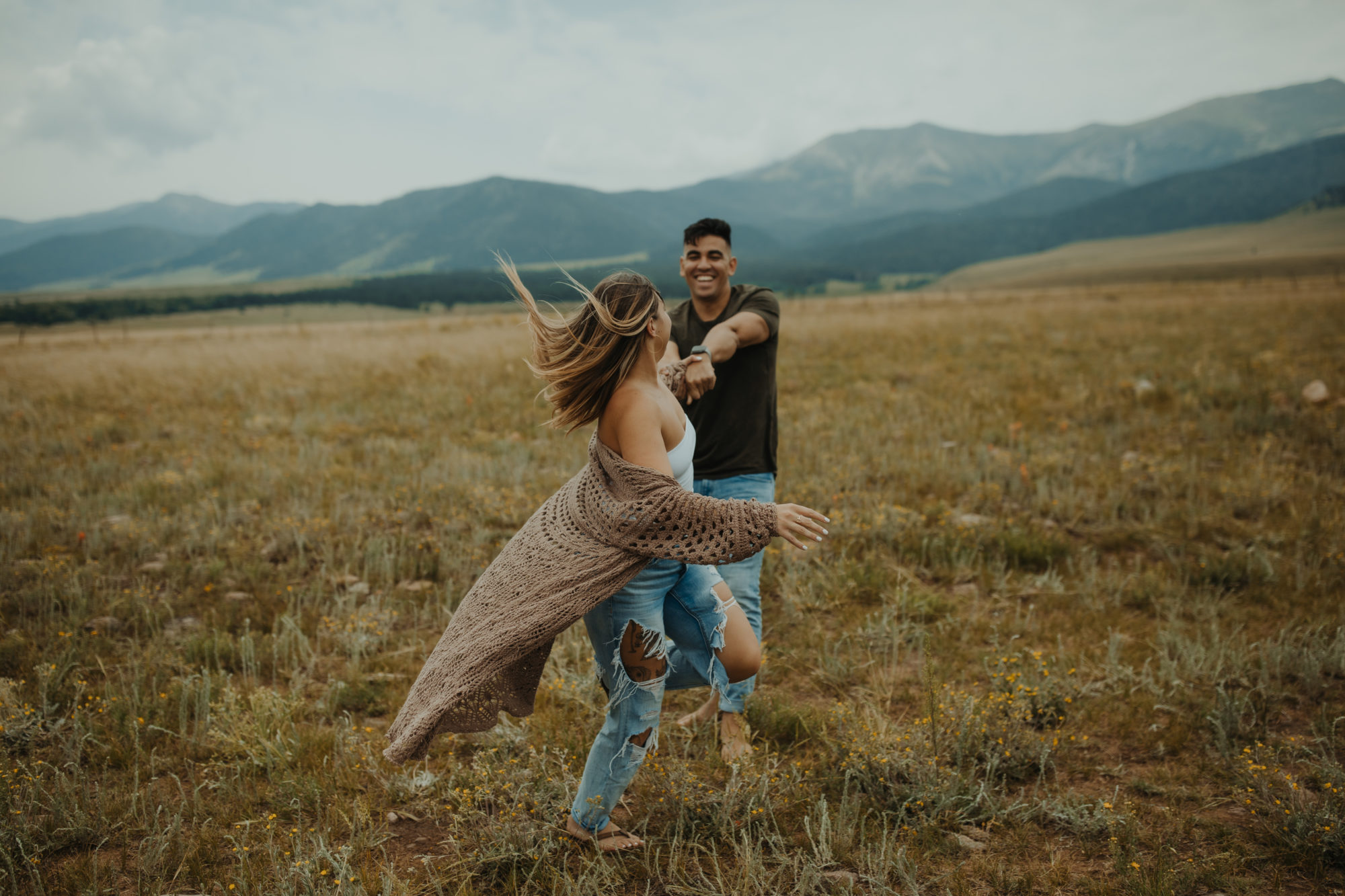 Couple in Mountain frolicking in field
