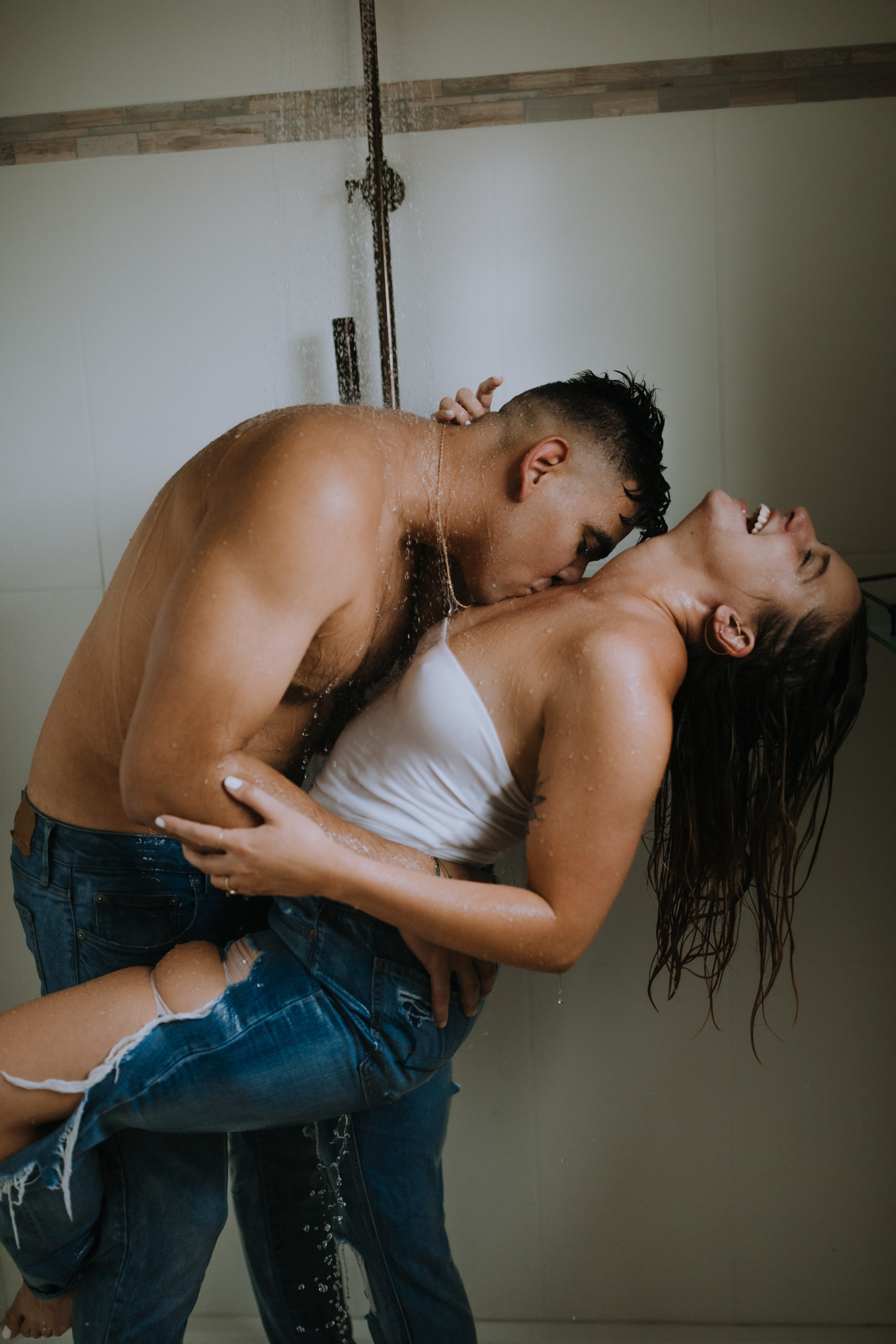 Grunge couple in shower with their clothes on for some steamy photos