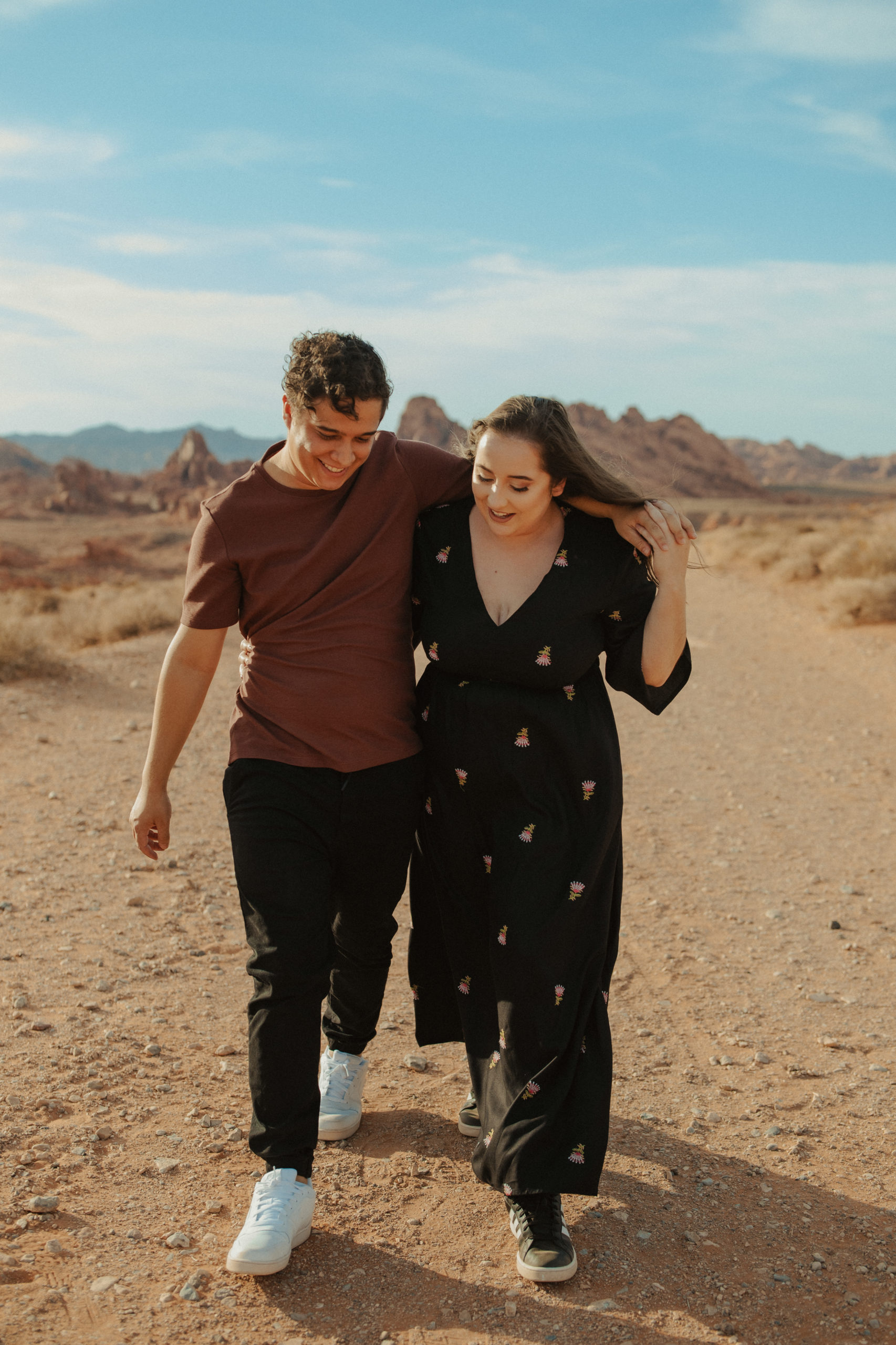 couple walking through the desert down a dirt road in valley of fire