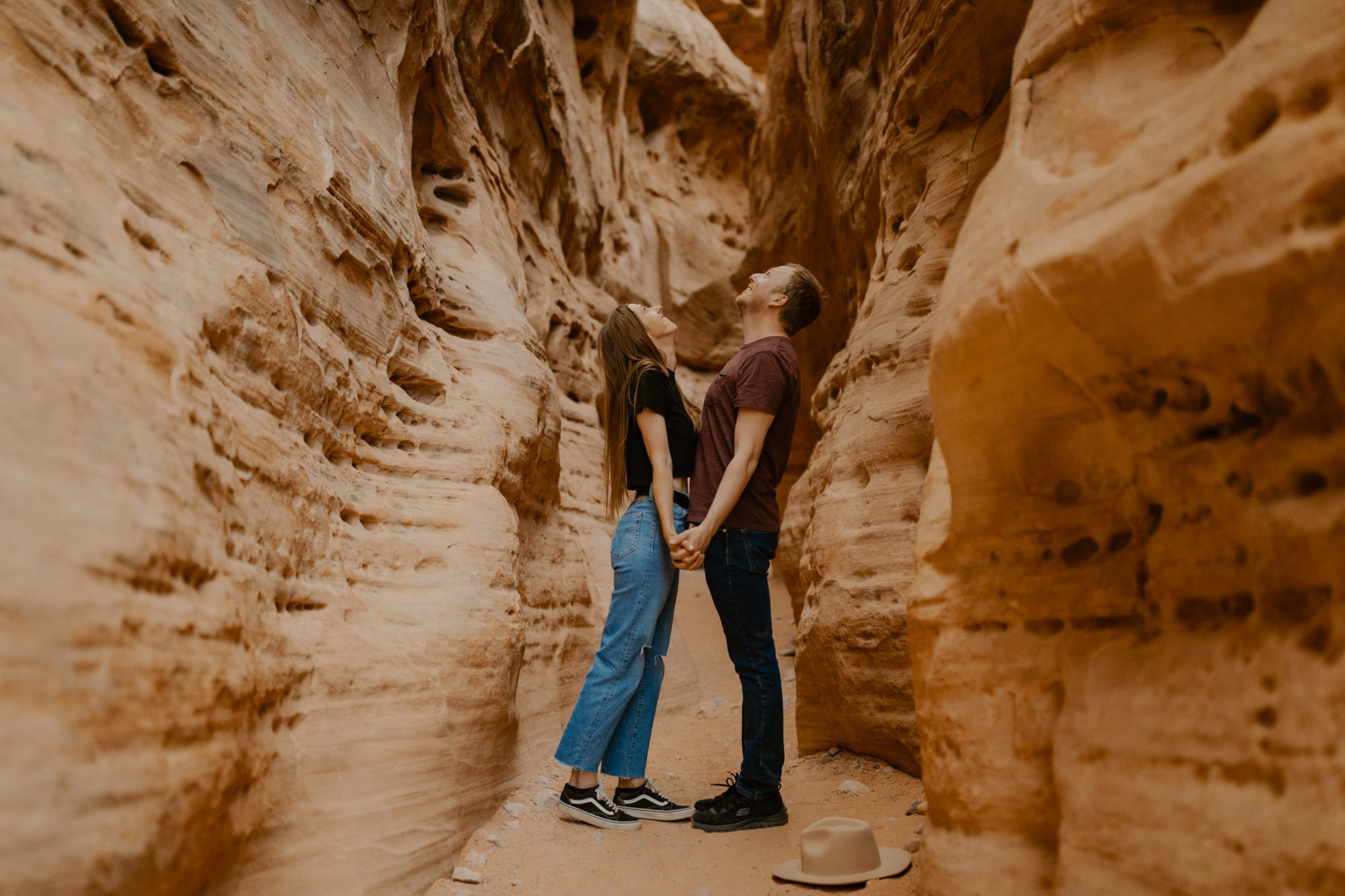 boho couple walking through valley of fire holding hands