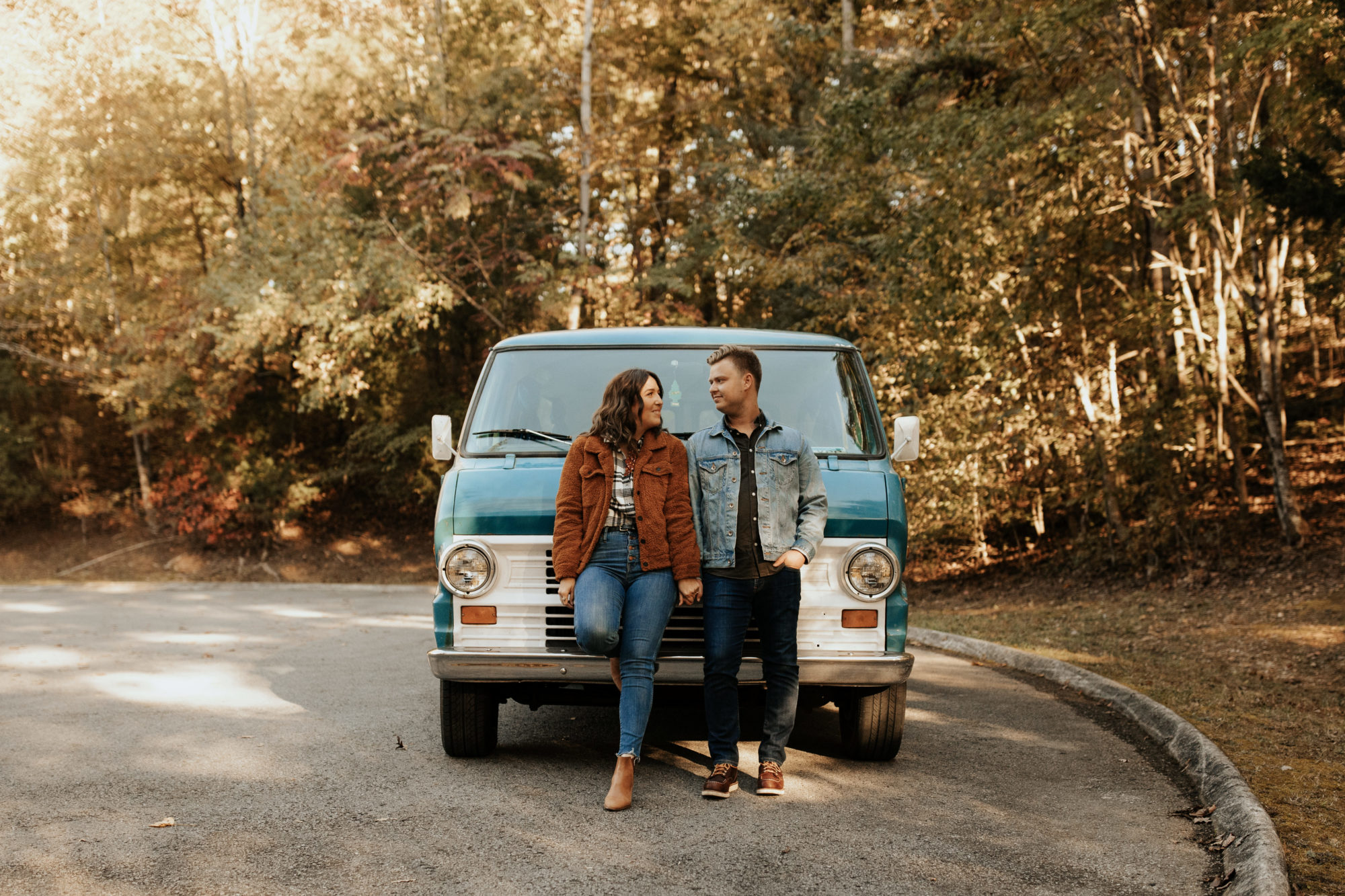 couple holding hands while standing in front of their campervan