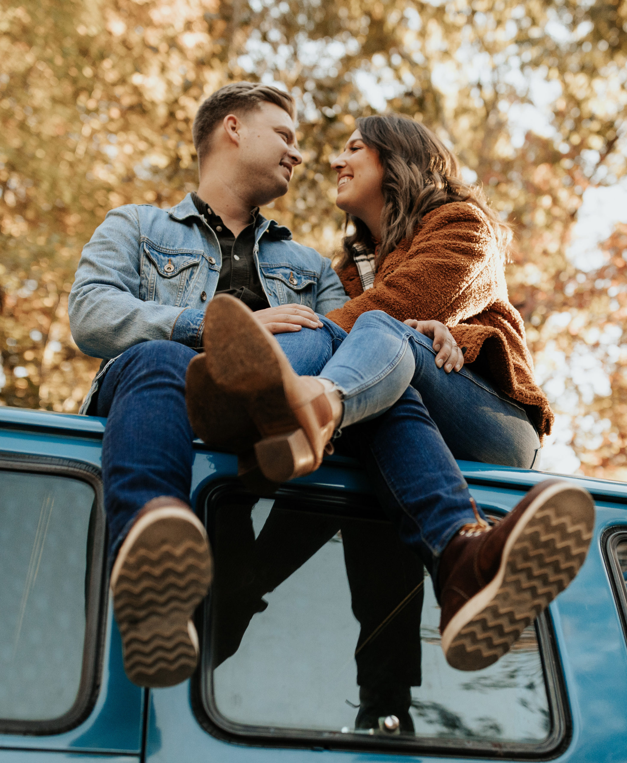 couple sitting on top of a campervan during their van life couples engagement session