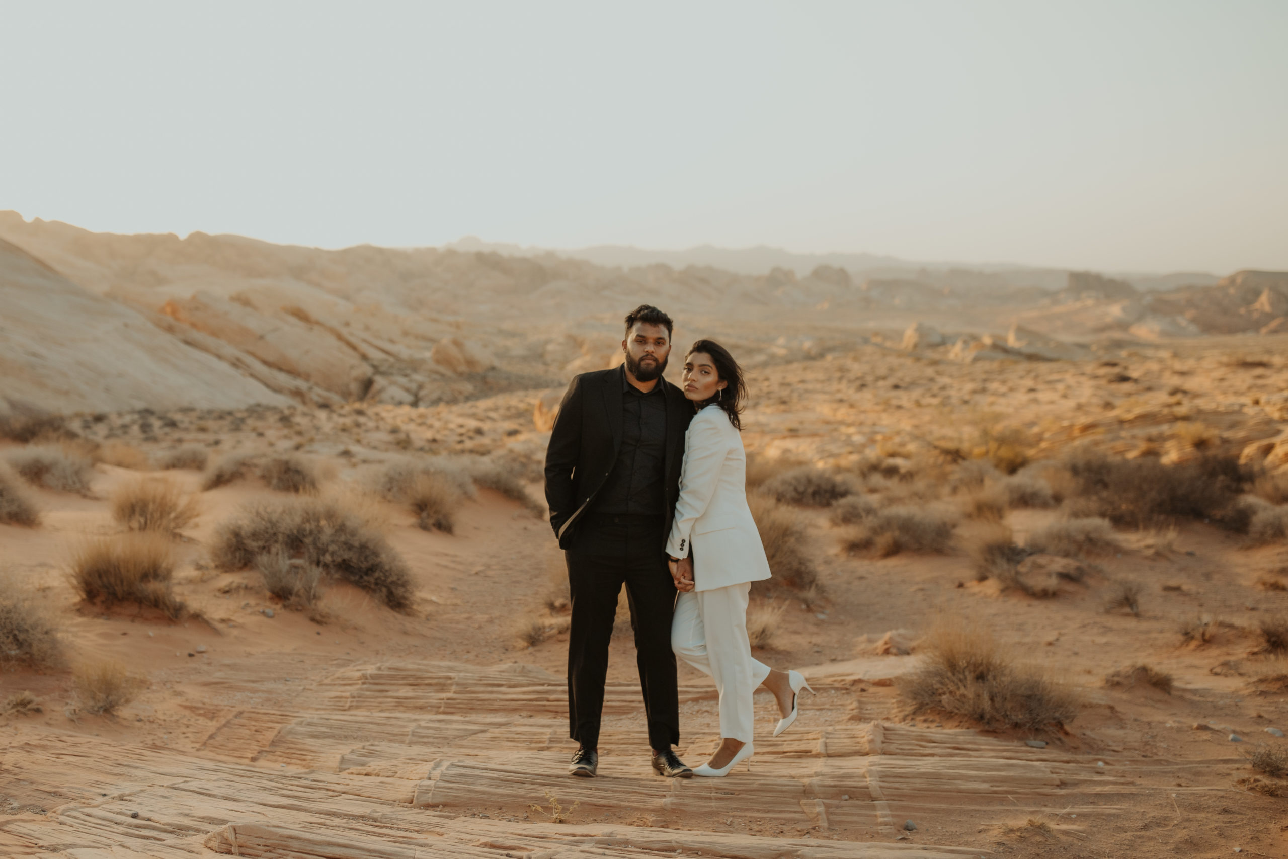 moody couple posing in the desert during golden hour