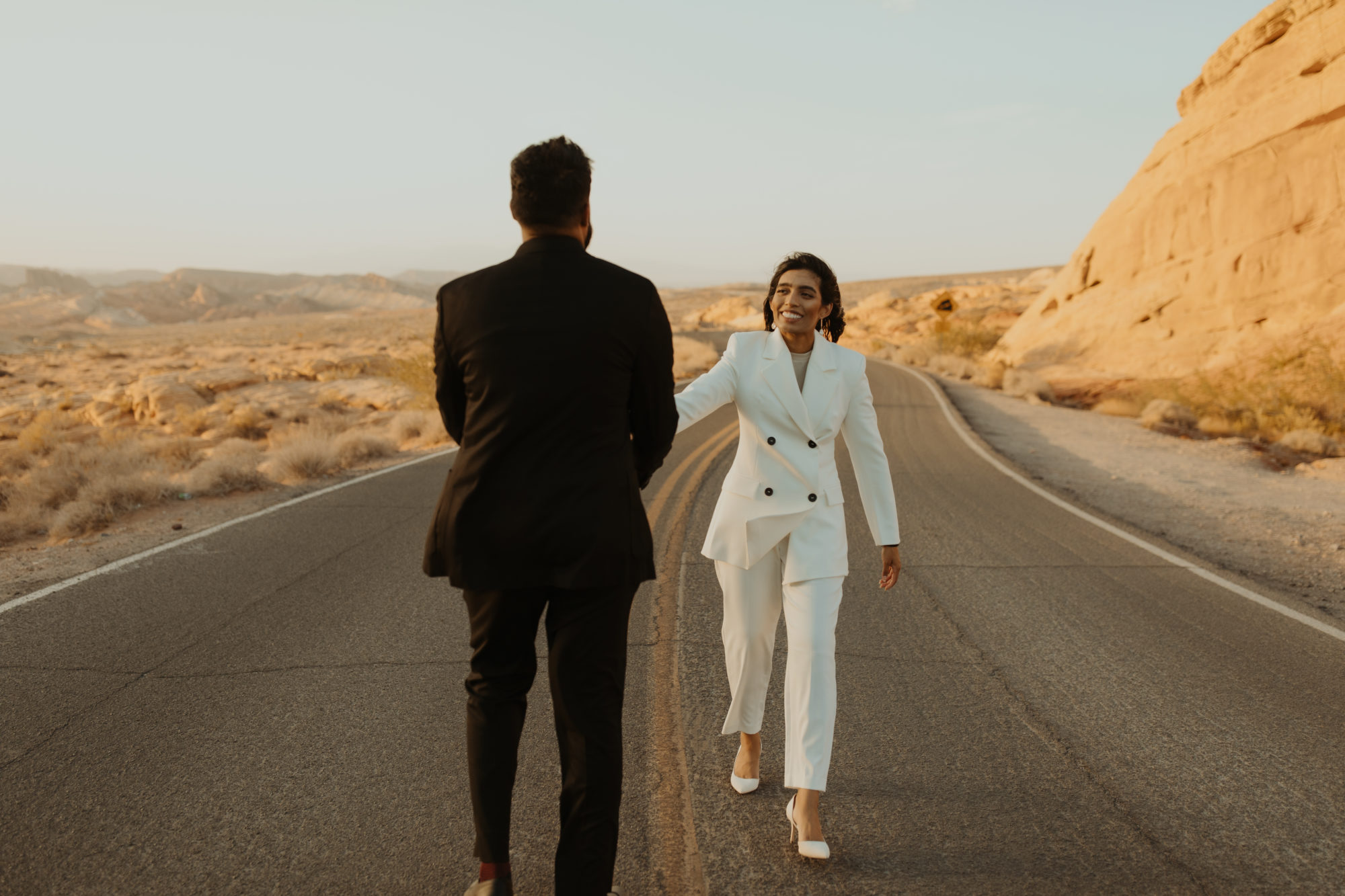 couple walking down the road holding hands in the desert