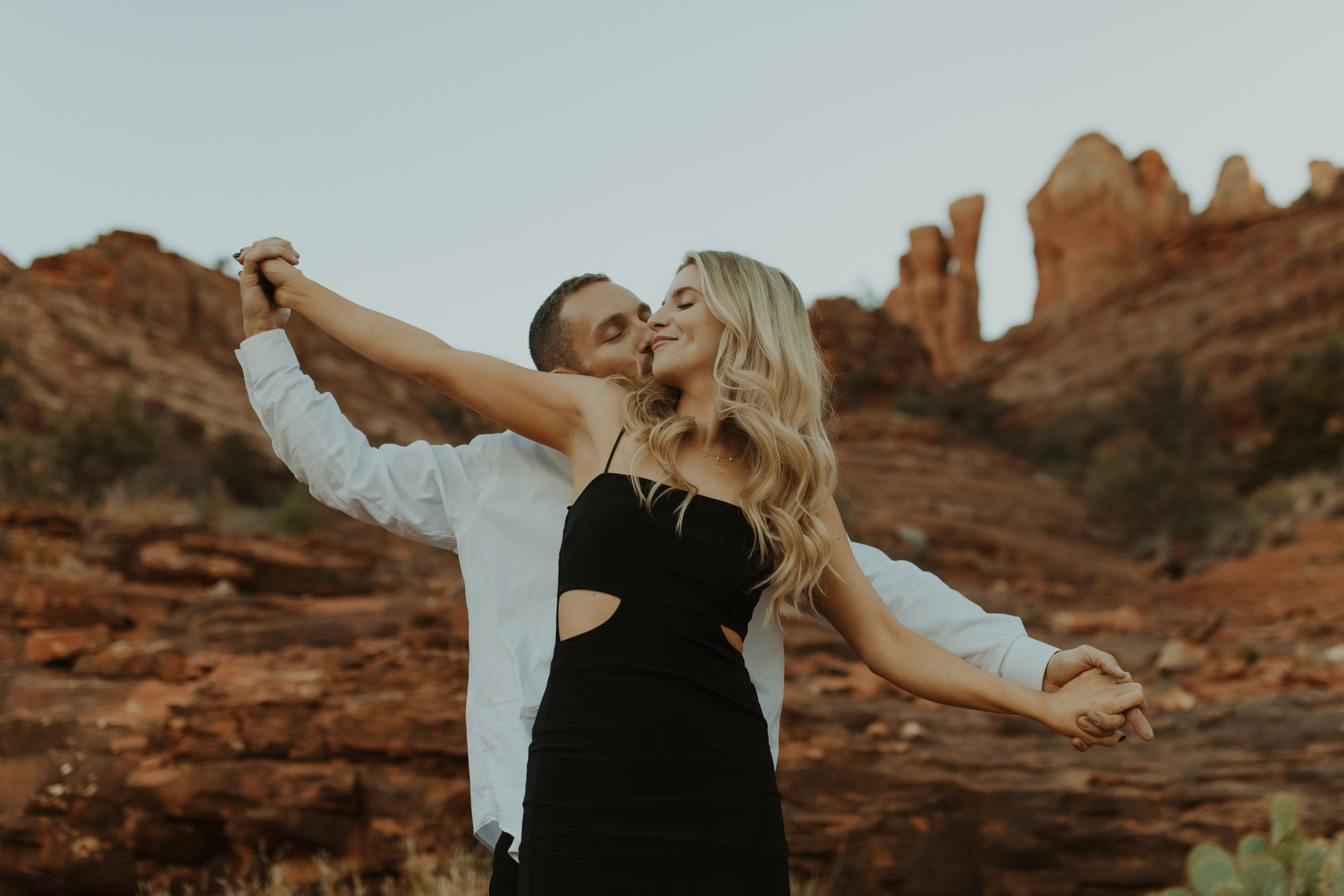 couple doing airplane arms in the desert