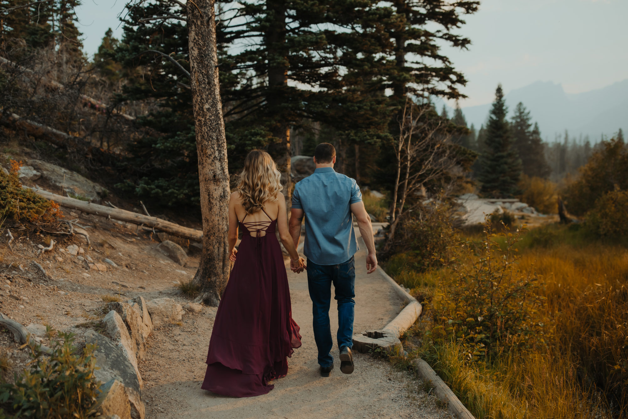 couple walking down a wooden walkway through the forest in the PNW