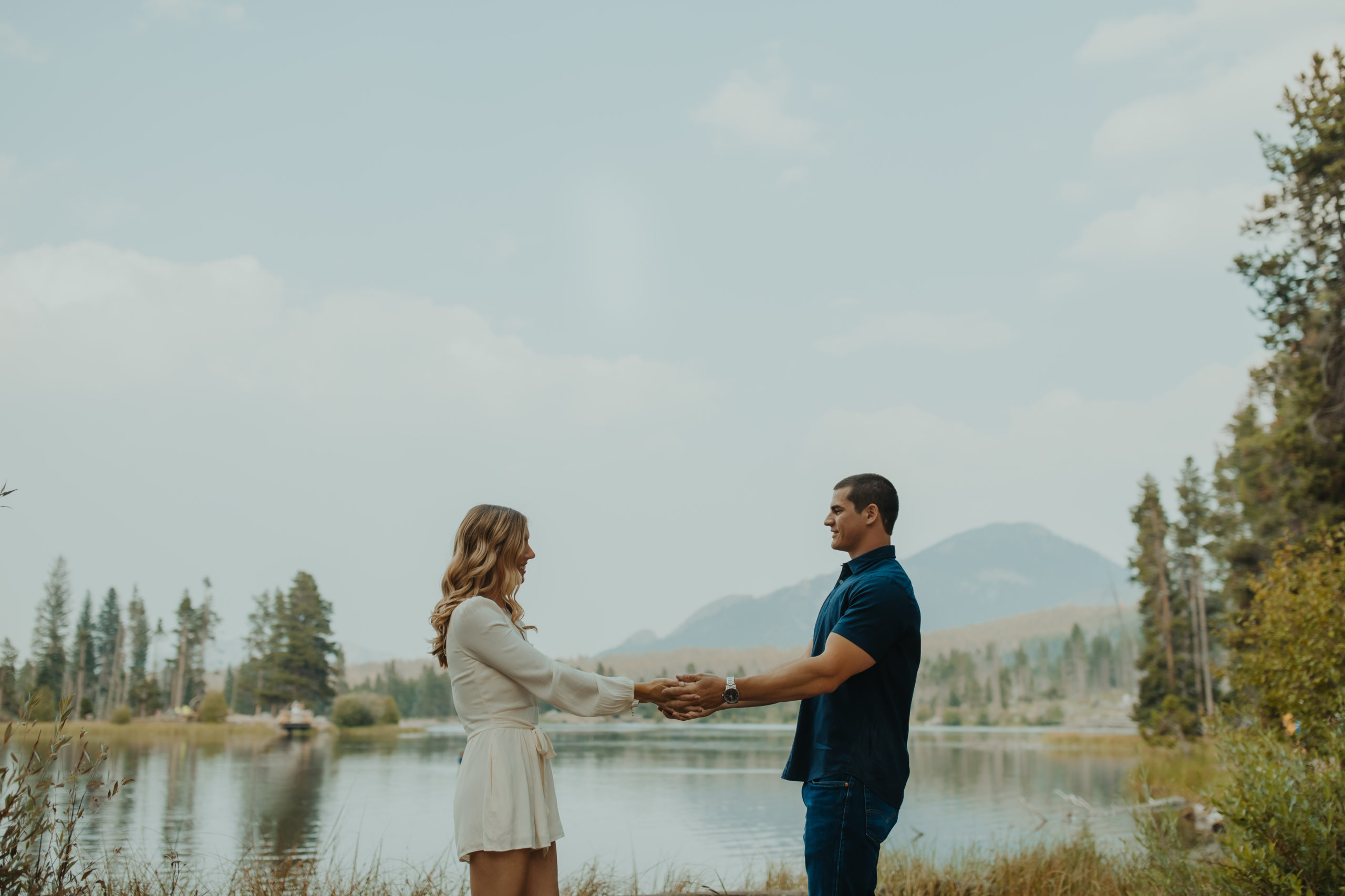 Couple holding hands in front of a lake 