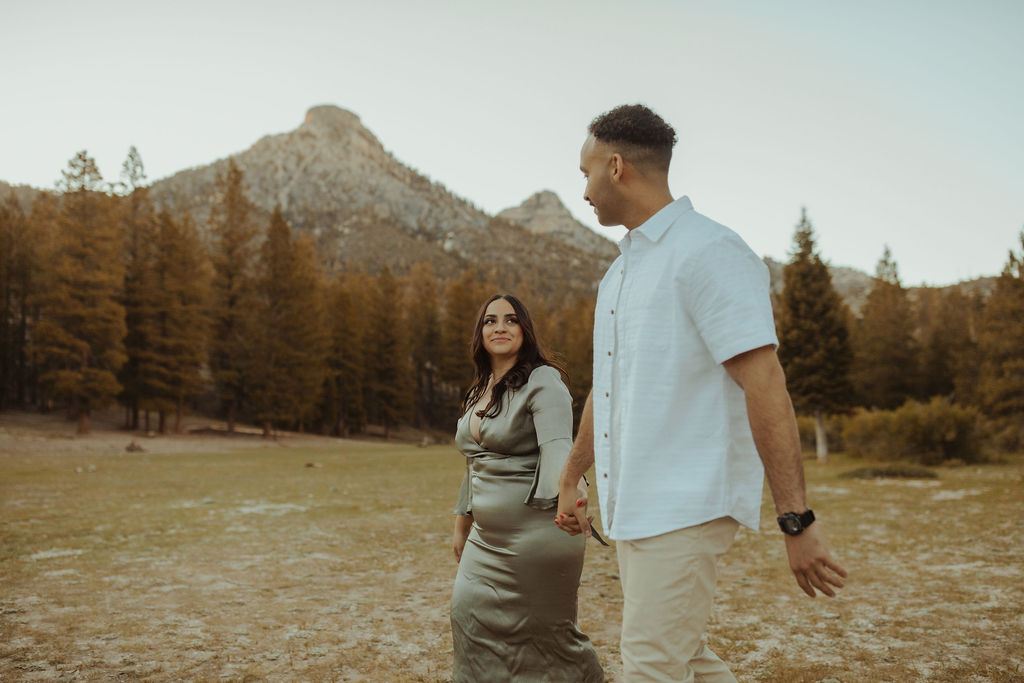 engaged couple walking through a field in mt. charleston nevada holding hands