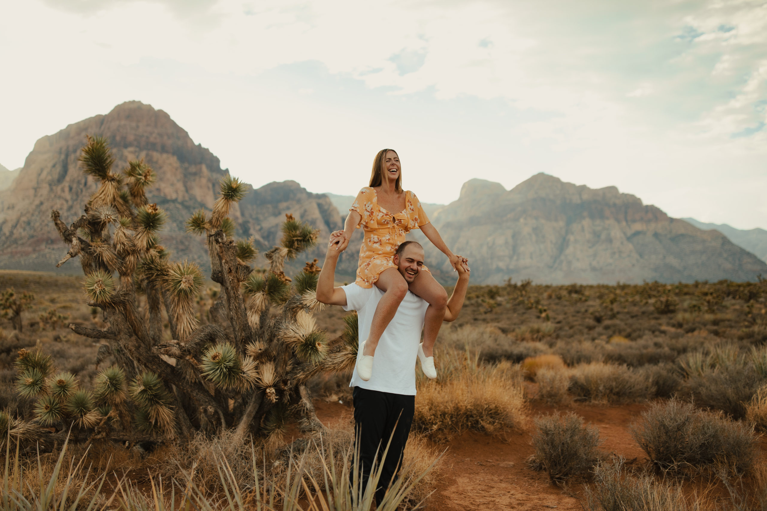 boyfriend giving girlfriend a shoulder ride in the desert