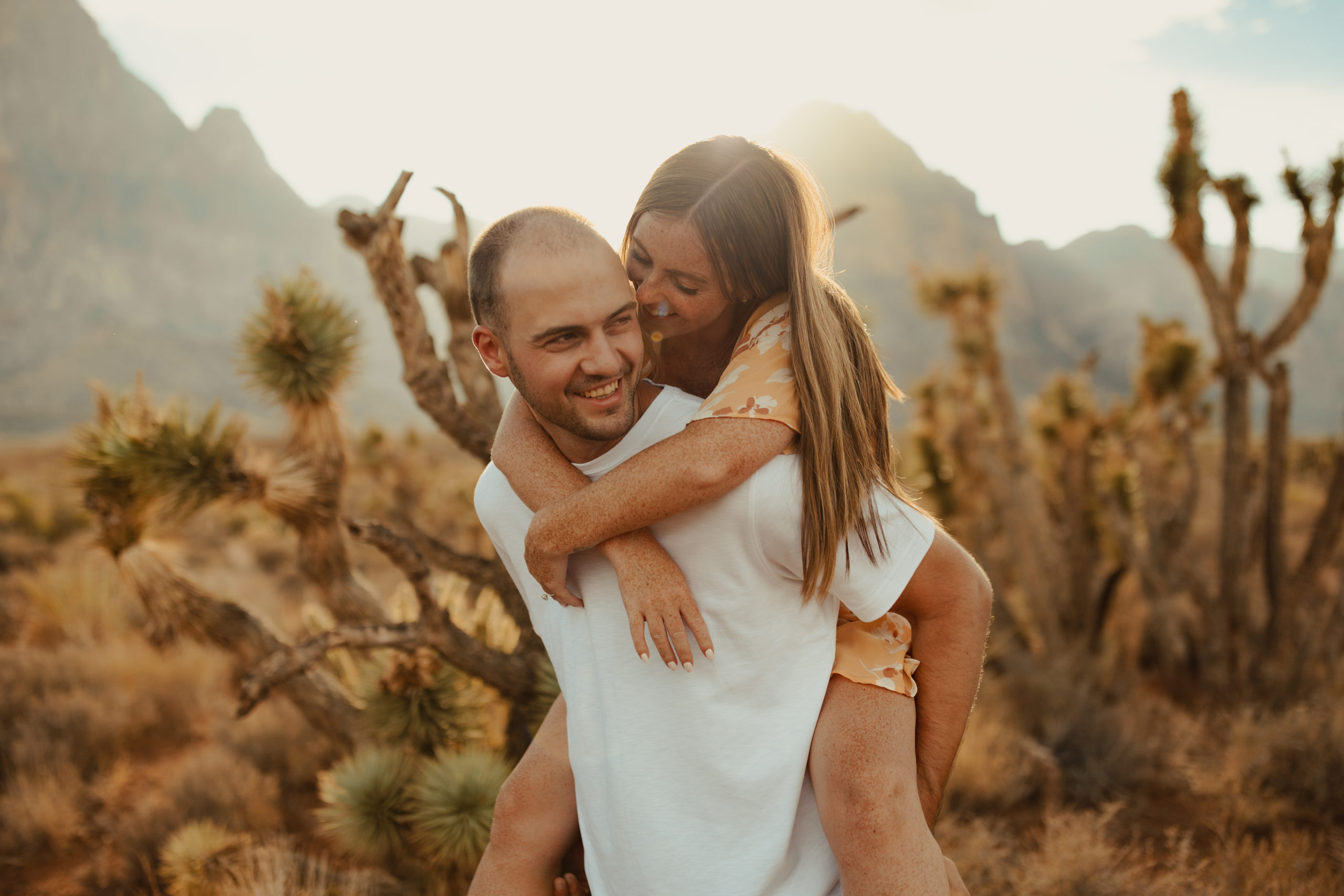 boyfriend giving his girlfriend a piggy-back ride in the desert