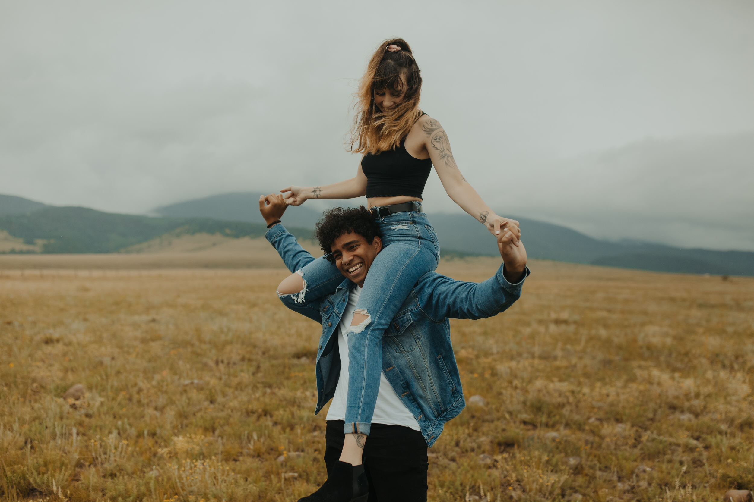 boyfriend giving girlfriend a shoulder ride in the mountains