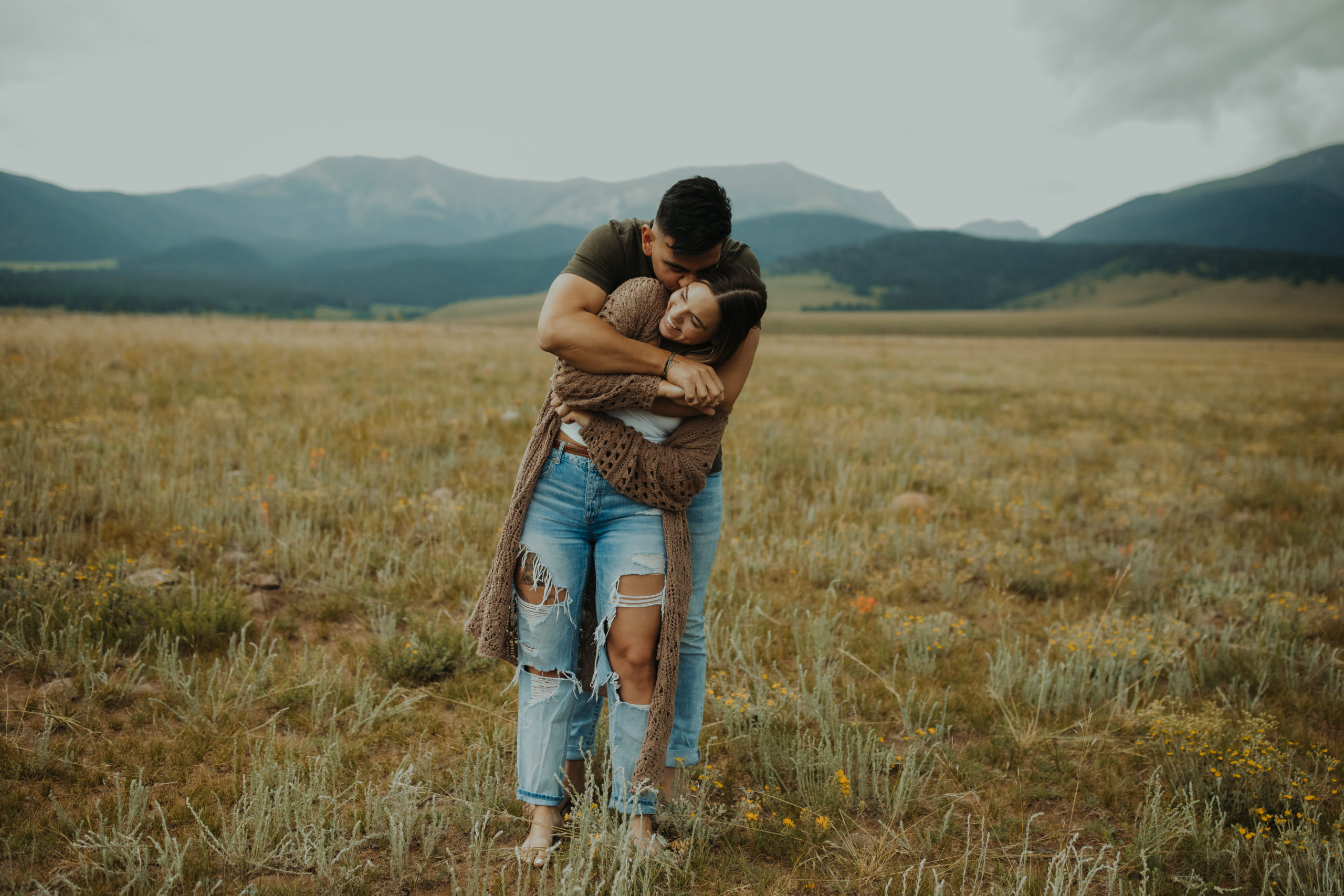 boyfriend wrapping girlfriend up in a bear hug