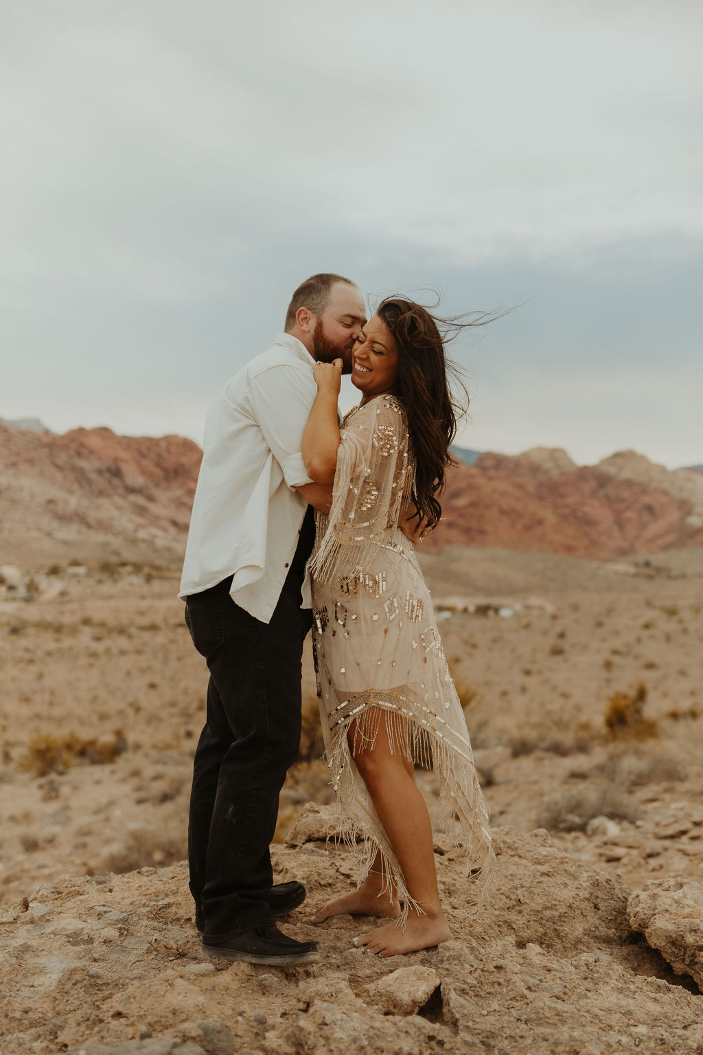 couple hugging and smiling in the desert of las Vegas during their vow renwewal photoshoot