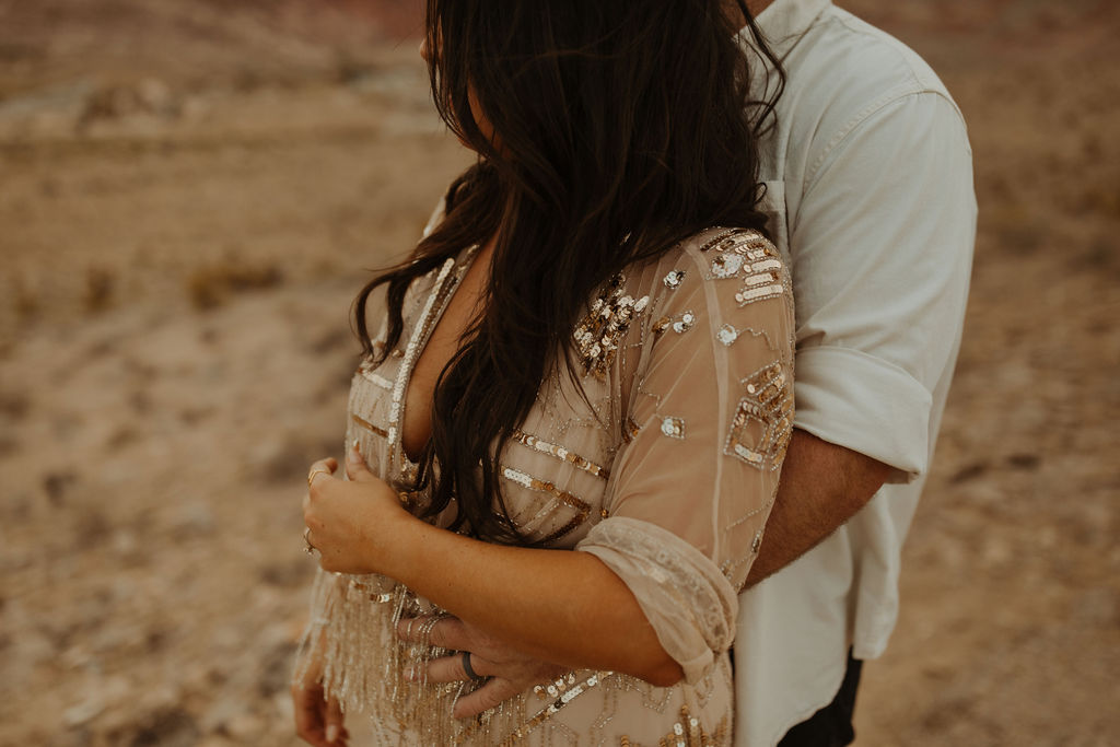 husband hugging his wife from behind in the desert in Las vegas during their vow renewal