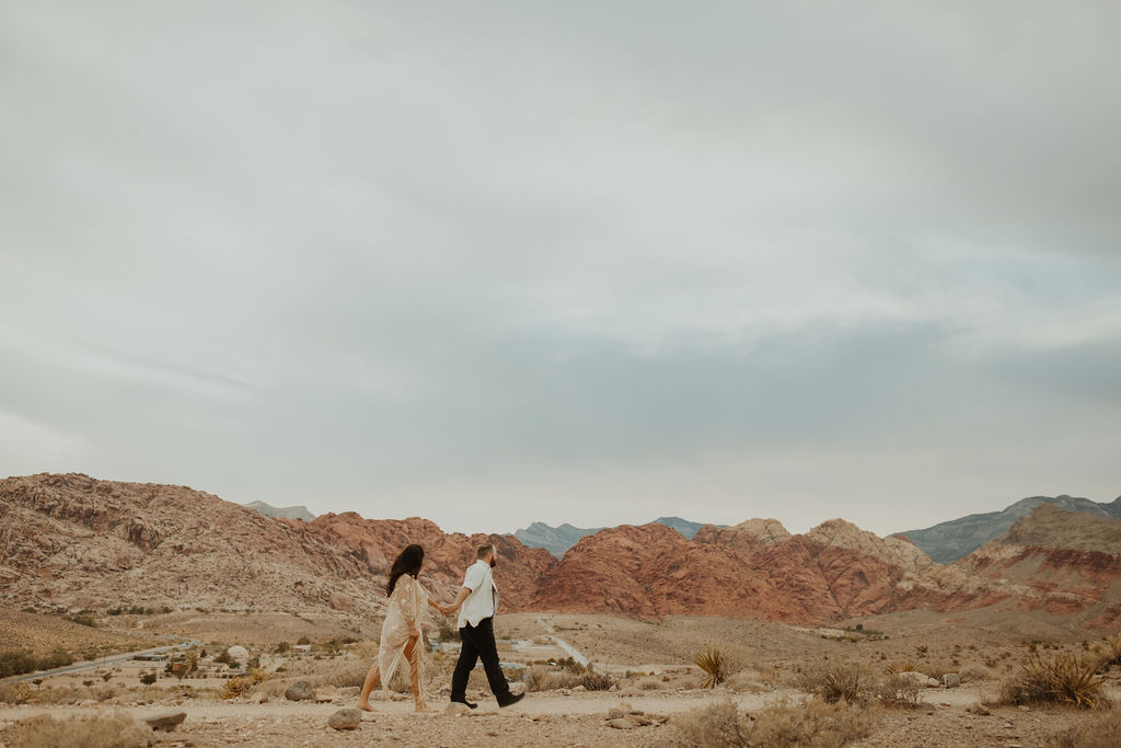 husband and wife walking through red rock canyon in las vegas during their vow renewal celebration