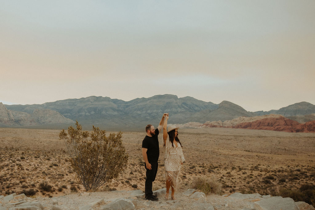 husband and wife twirling around in the desert during their vow renewal