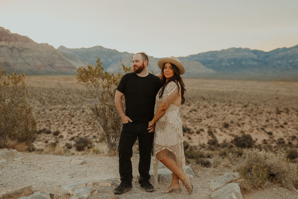 couple holding hands staring off into the distance in the las vegas desert