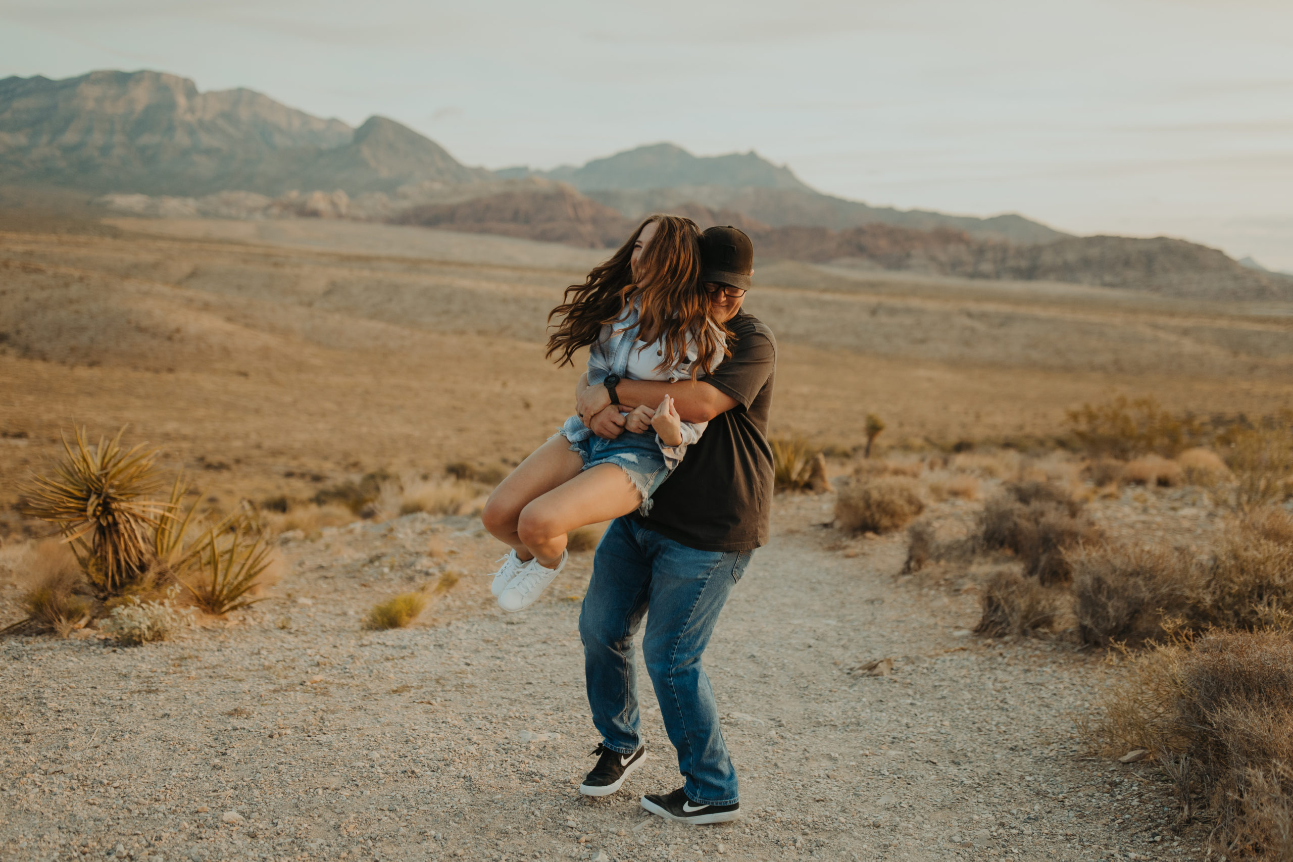 boyfriend lifting and twirling his girlfriend around in the desert