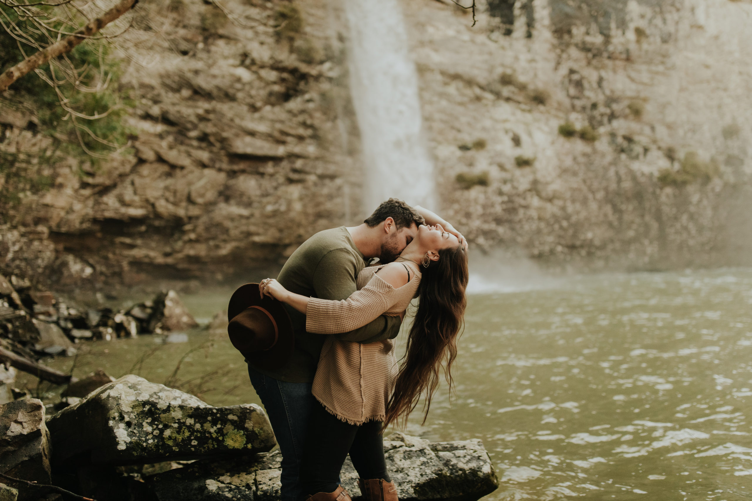fiance leaning his girlfriend back into a dip in front of a waterfall