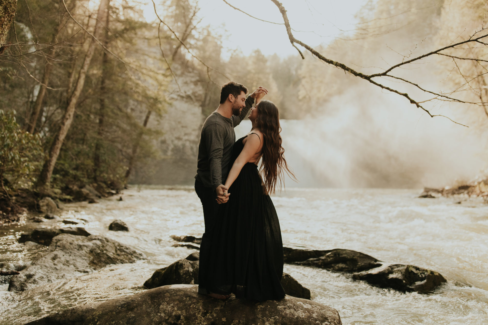 couple being playful in front of waterfall