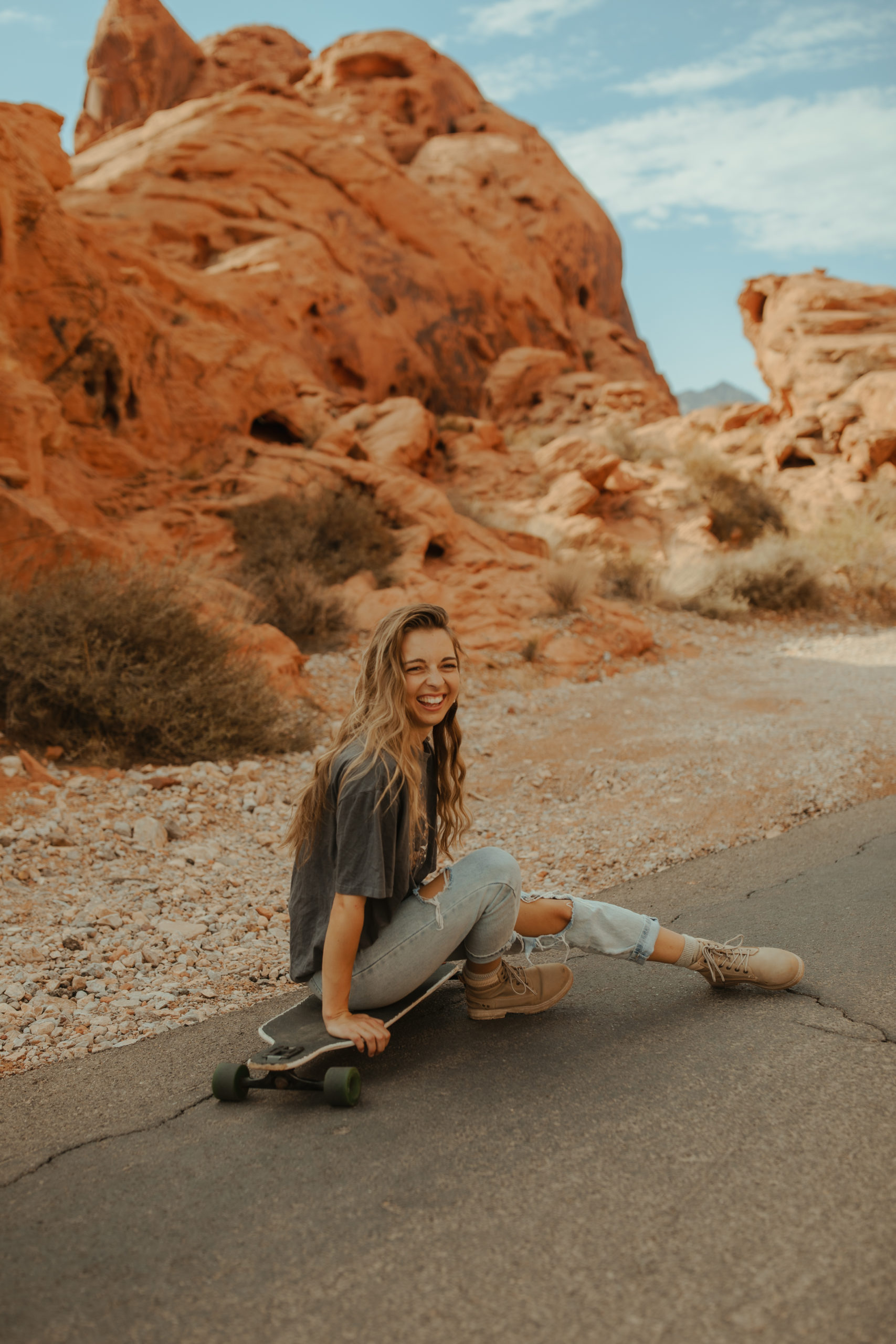 Girl with her skateboard and desert in the background