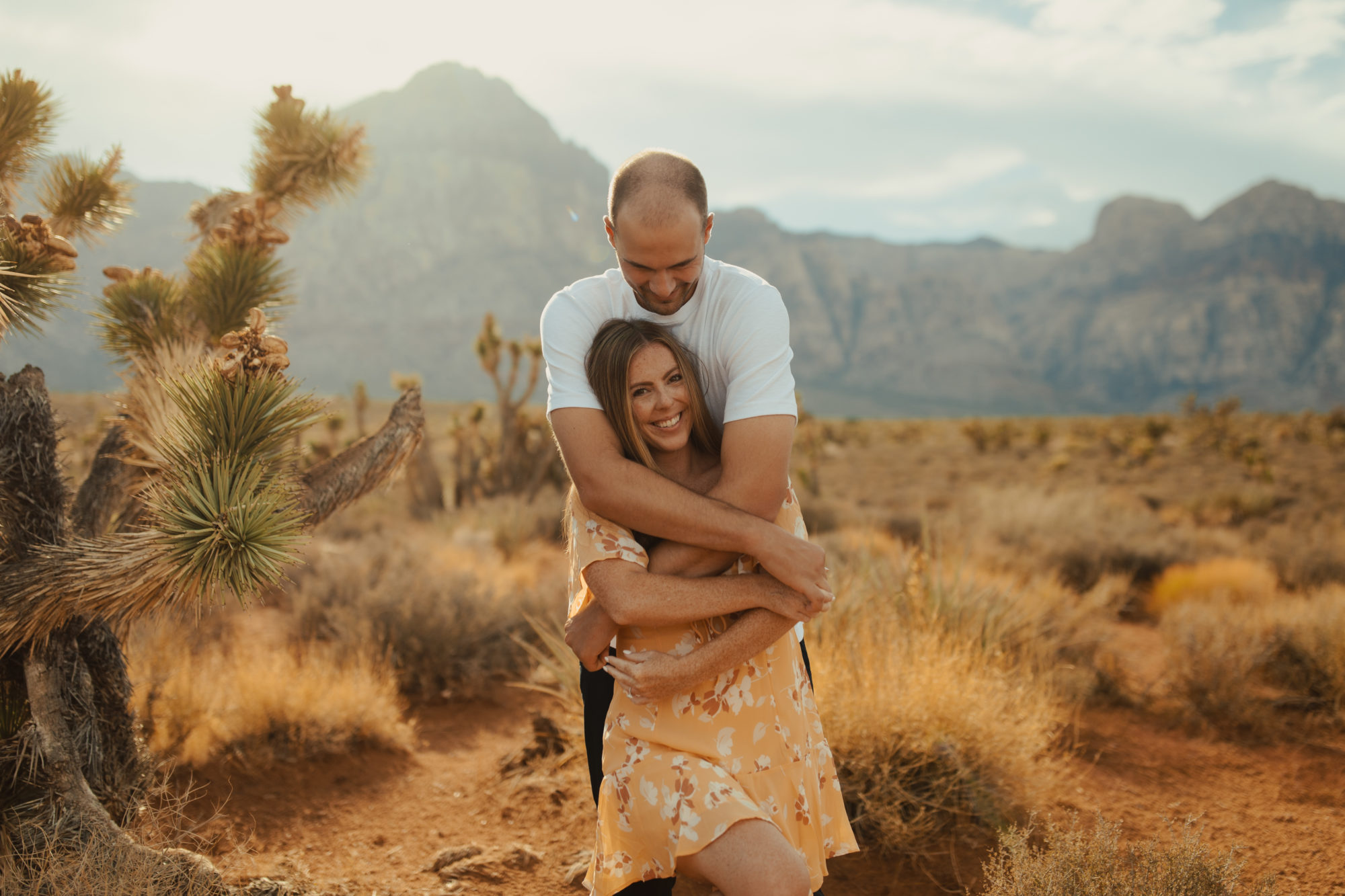 boyfriend hugging his girl friend from behind in the desert