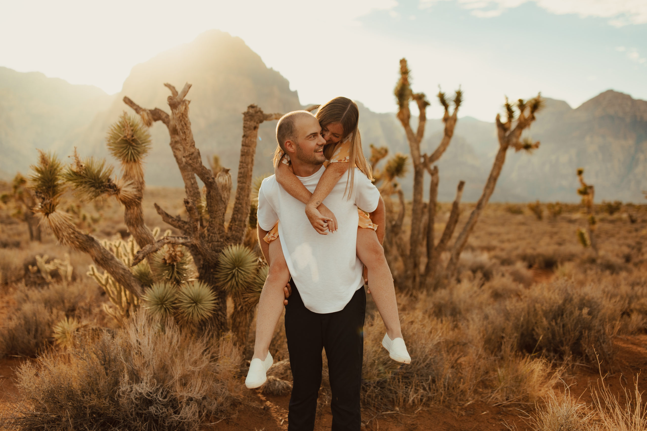 fiance giving his girl friend a piggy back ride in the desert