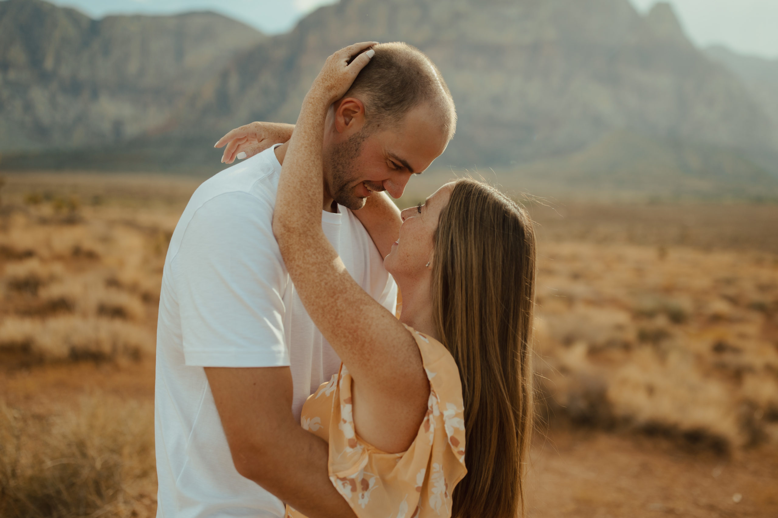close up portrait of engaged couple smiling at each other during golden hour in the desert