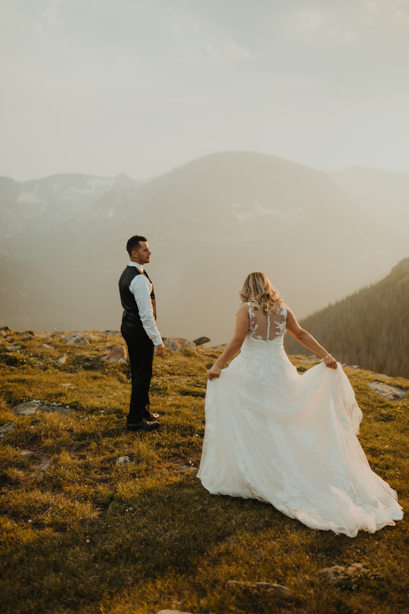 bride walking up to groom in rocky mountain national park with her dressed flared out