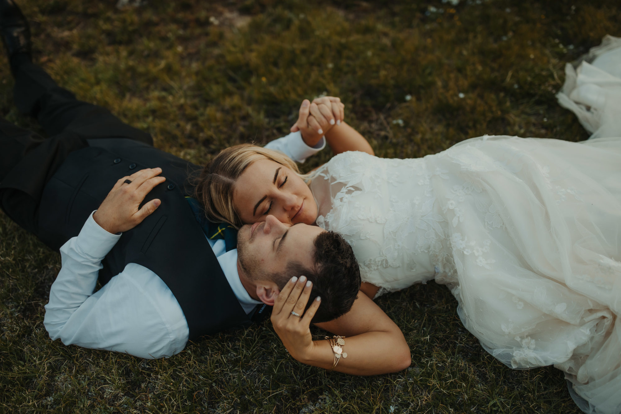 bride and groom laying down while heads together and eyes closed in rocky mountain national park