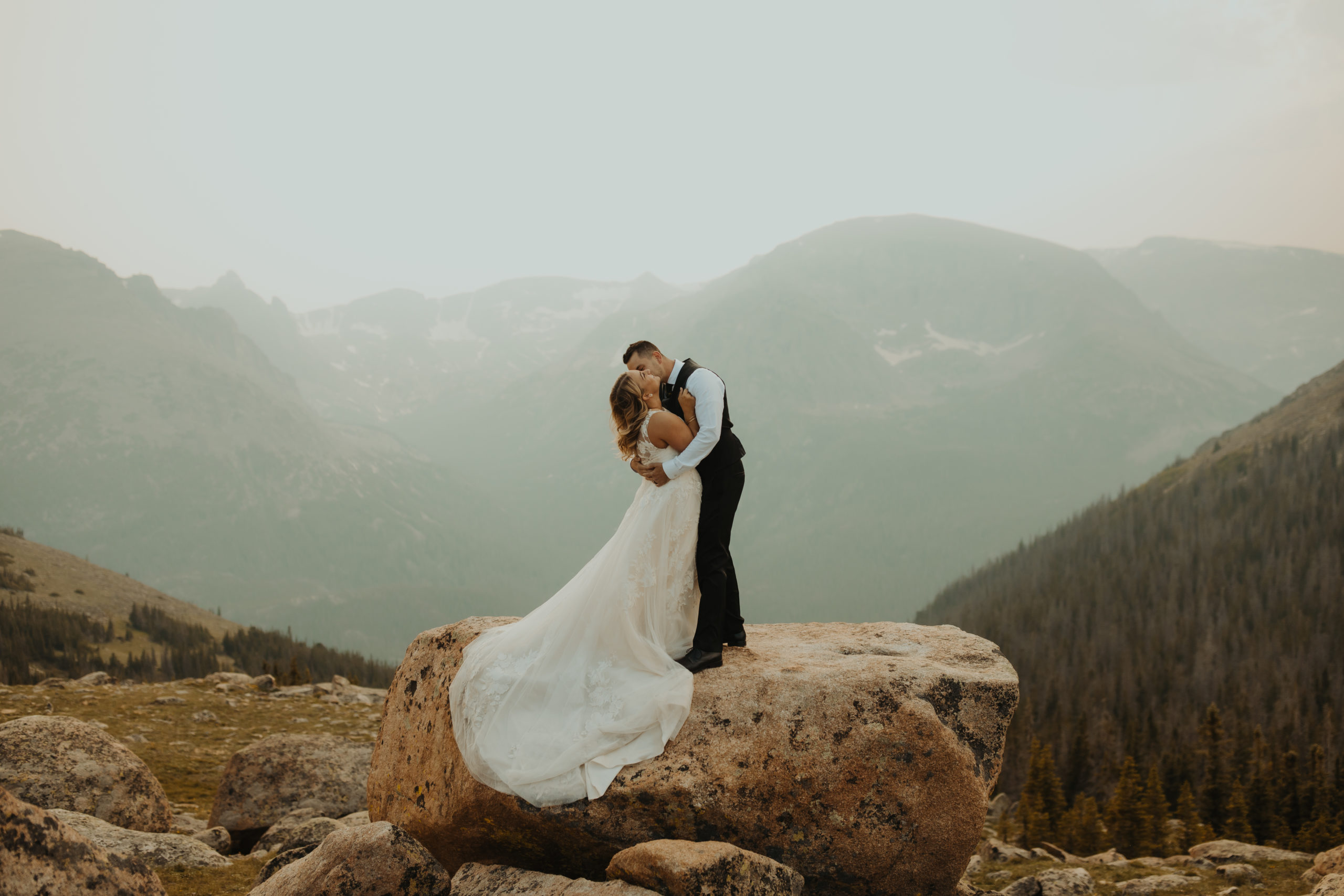 Bride and Groom Kissing on top of a rock in rocky mountain national park