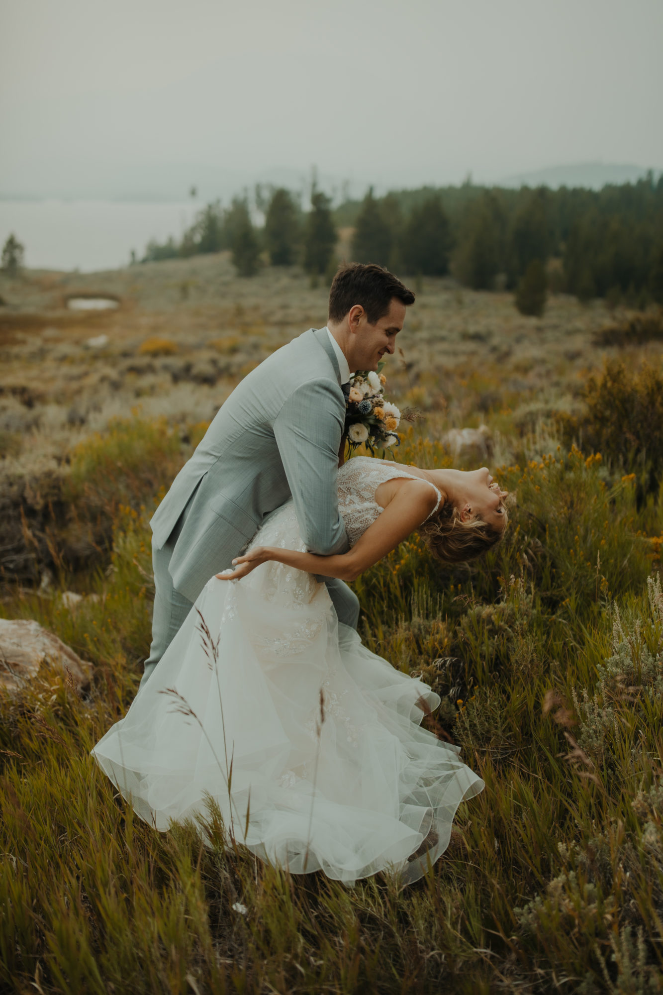 groom dipping bride back in a wildflower meadow in dillon colorado
