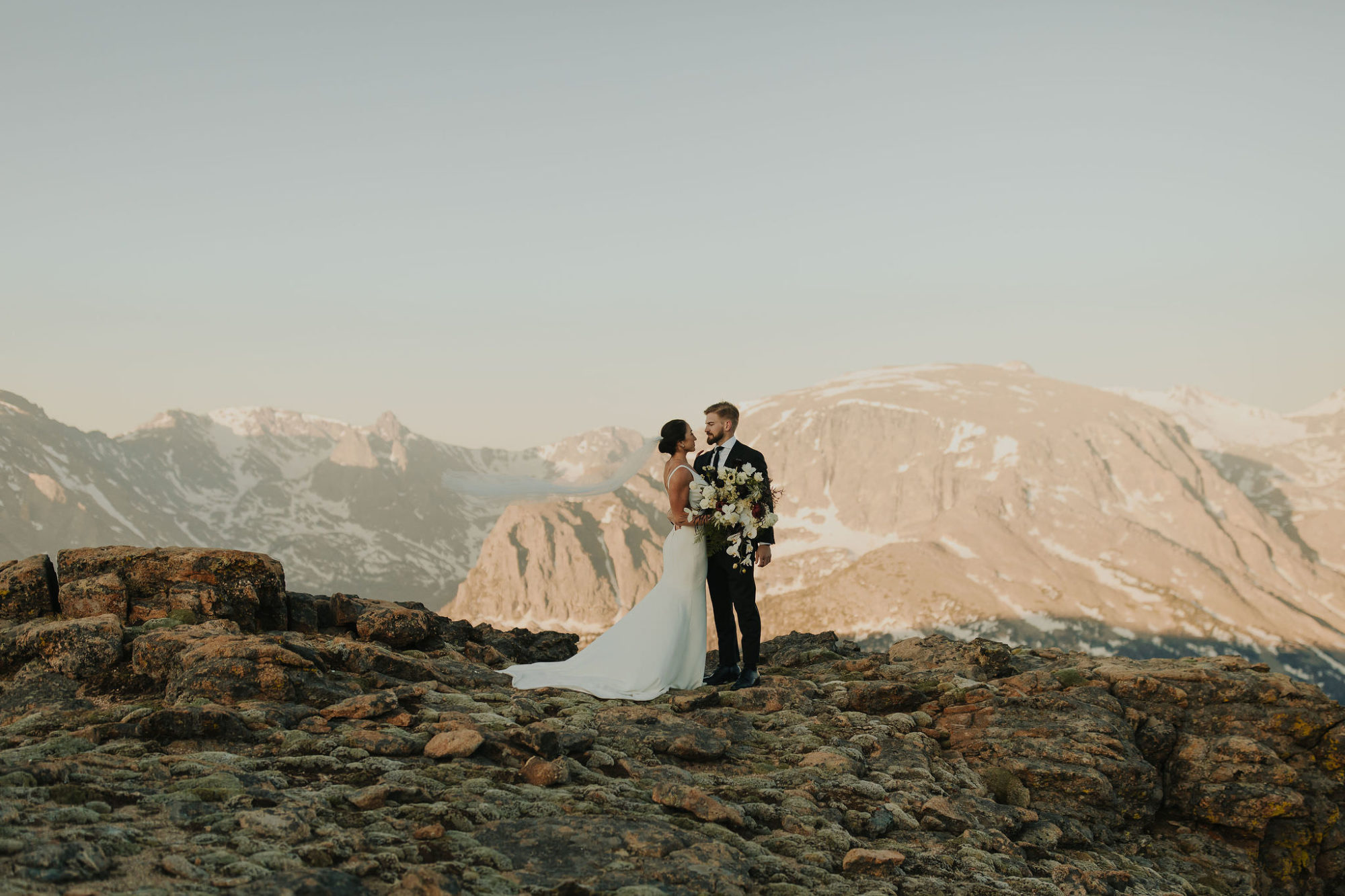 bride and groom standing on a mountain in rocky mountain national park in colorado