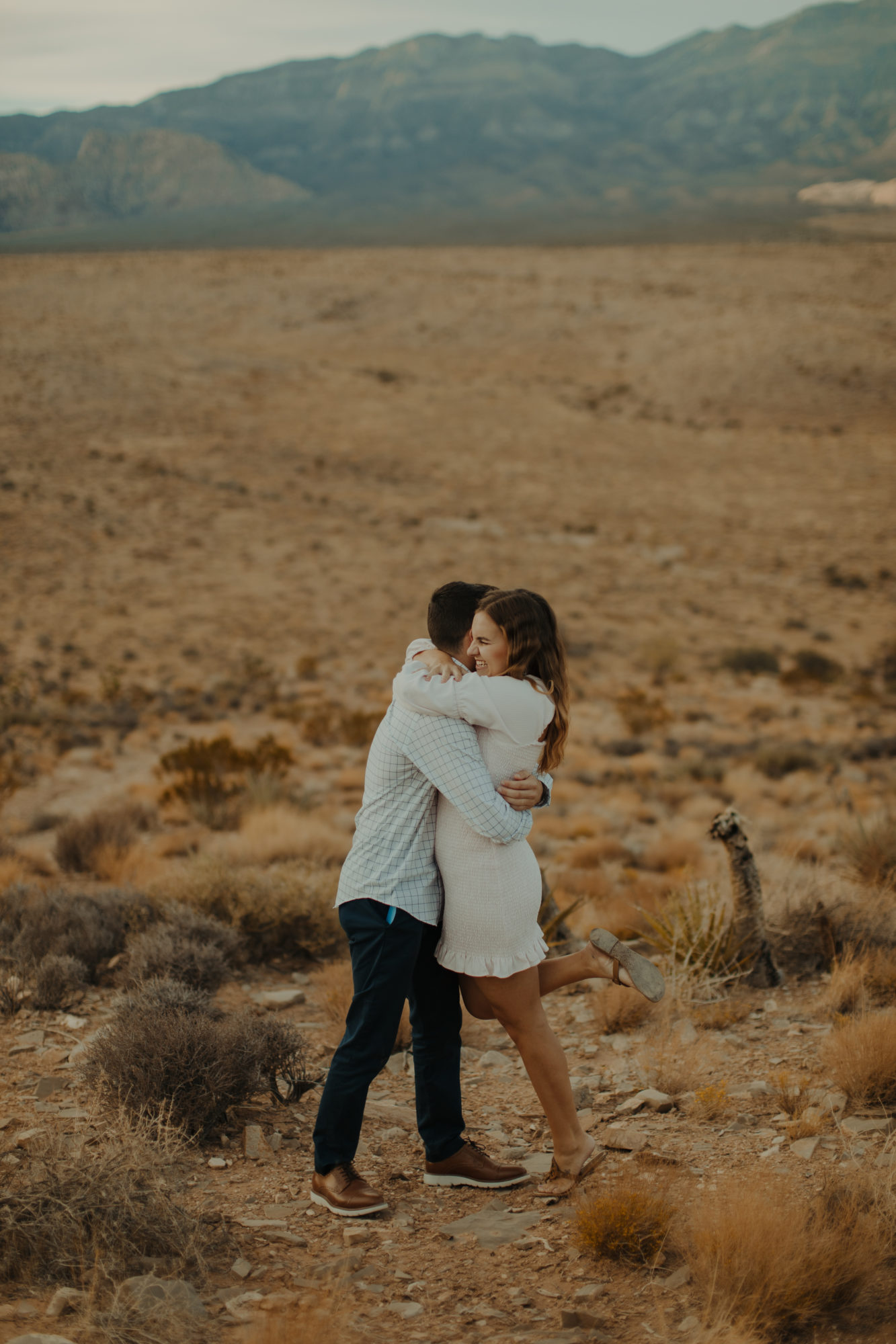 fiancee hugging her boyfriend after he proposed in the desert