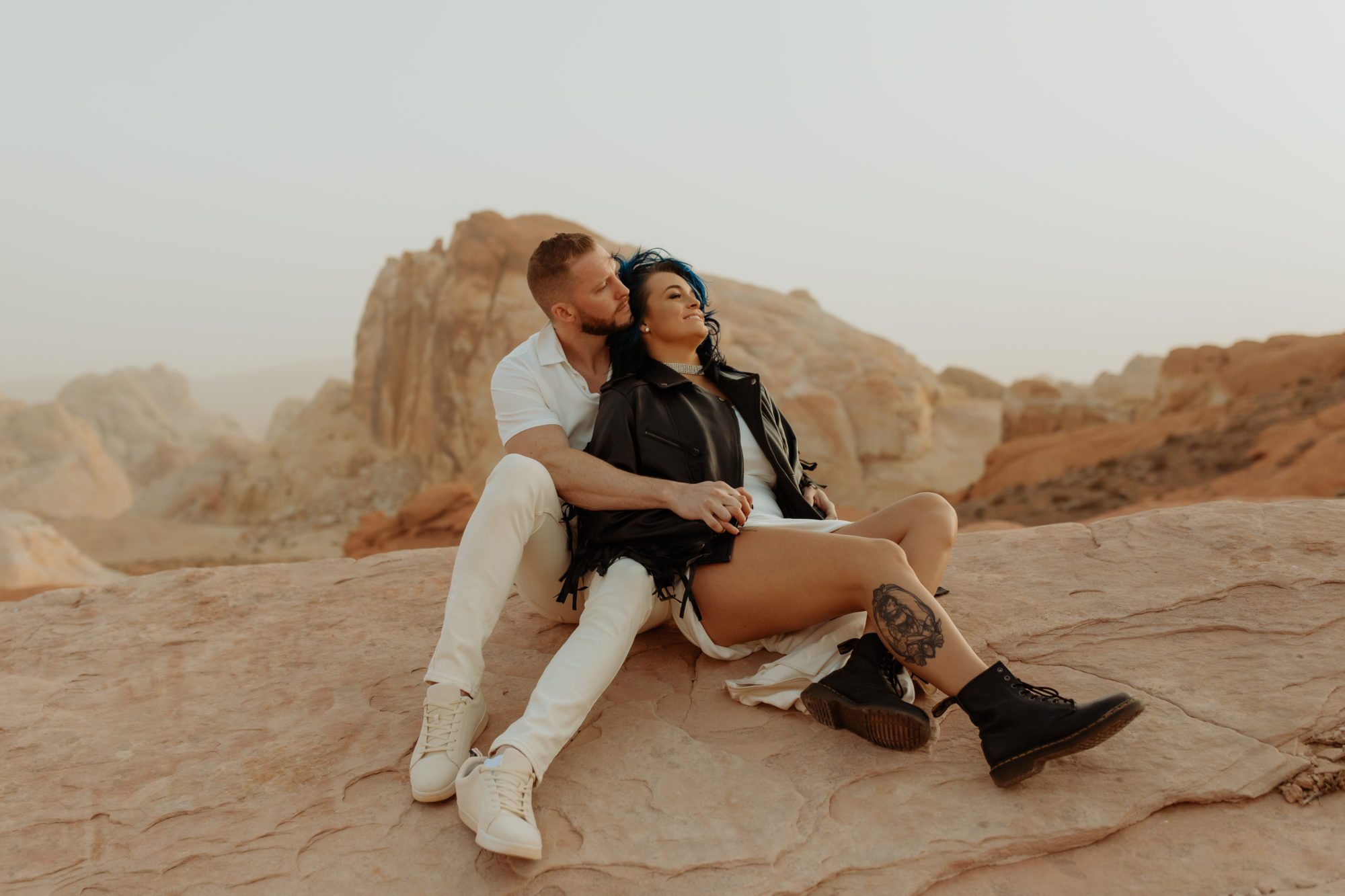 grunge engaged couple sitting on the white rocks in valley of fire in valley of fire during a dust storm 