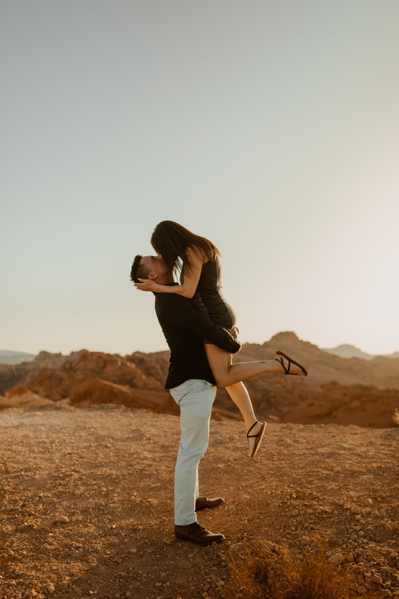fiance picking his girl friend up and kissing her after he just propsed to her in the desert at sunset