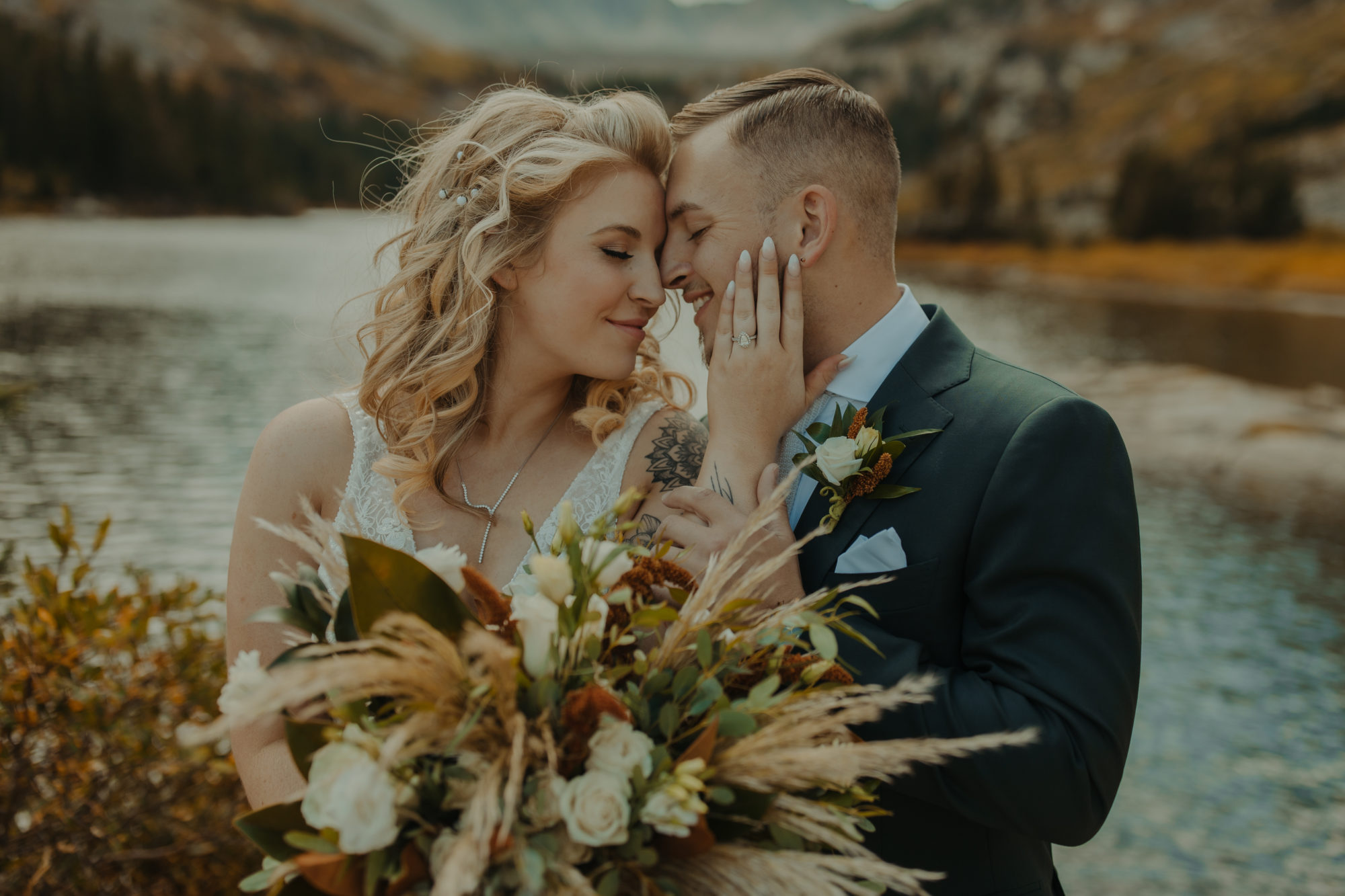 close-up portrait of bride and grooms faces in front of an alpine lake in Breckenridge Colorado