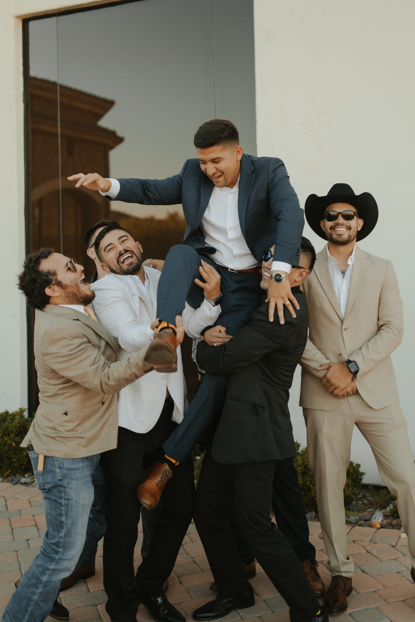 groom getting lifted into the air by his guy friends after the wedding ceremony