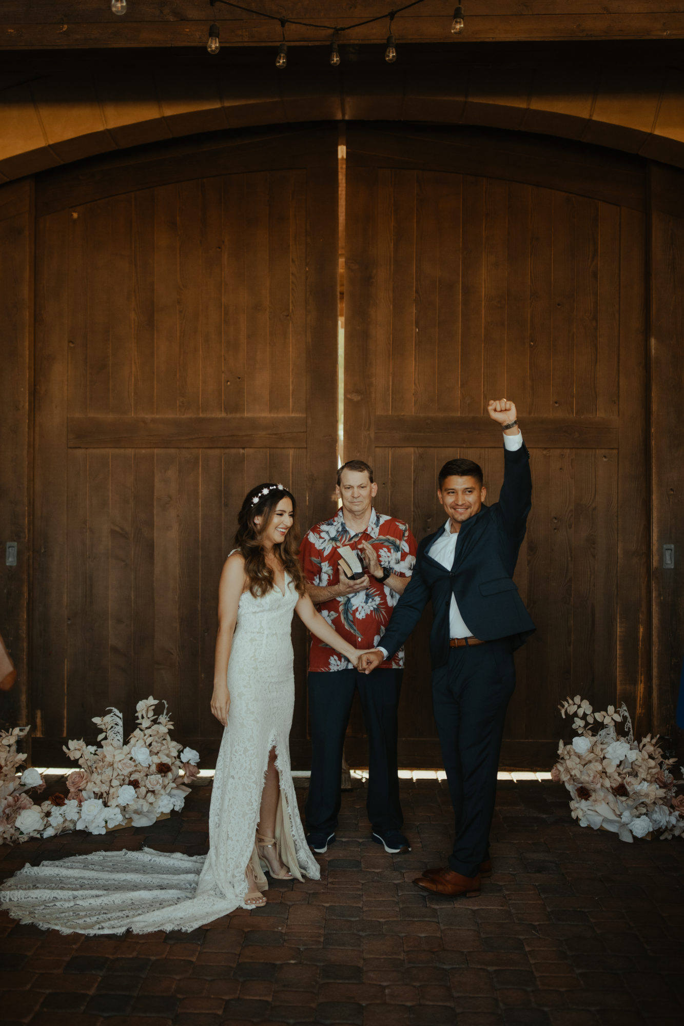 groom fist pumping in celebration after being pronounced husband and wife by the officiant during their wedding ceremony