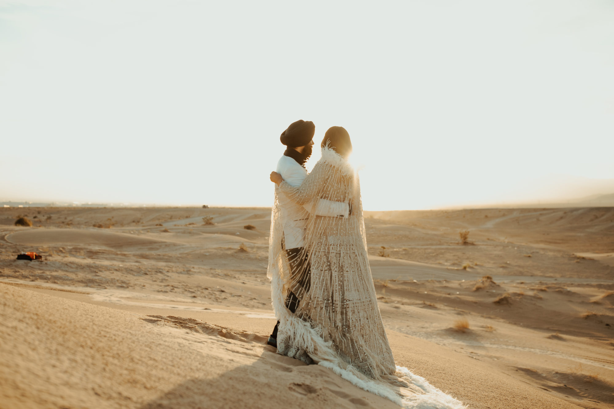 bride and groom hugging and watching the sunset together in the Nevada desert