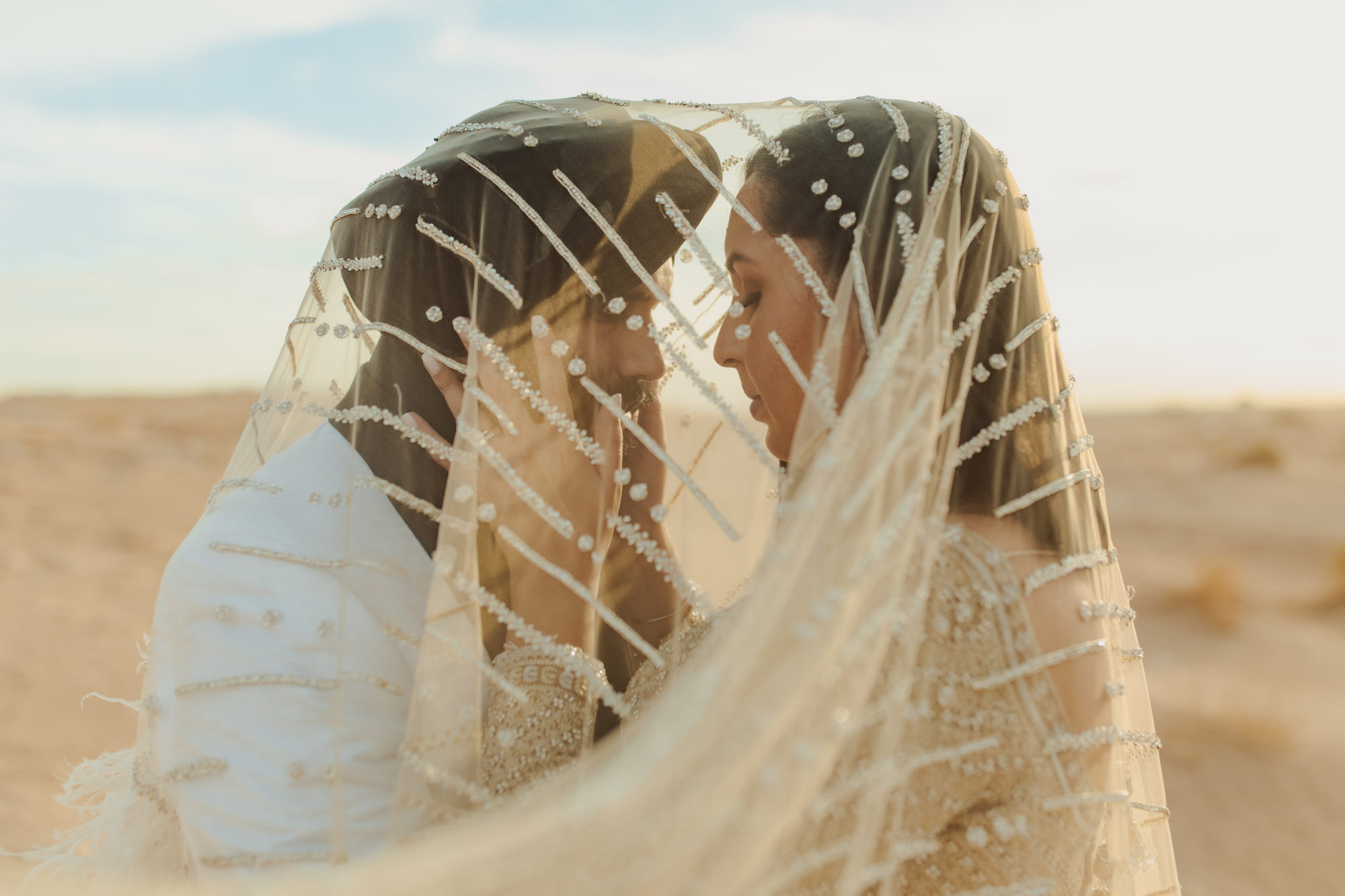 bride and groom under the brides veil in the desert in Nevada
