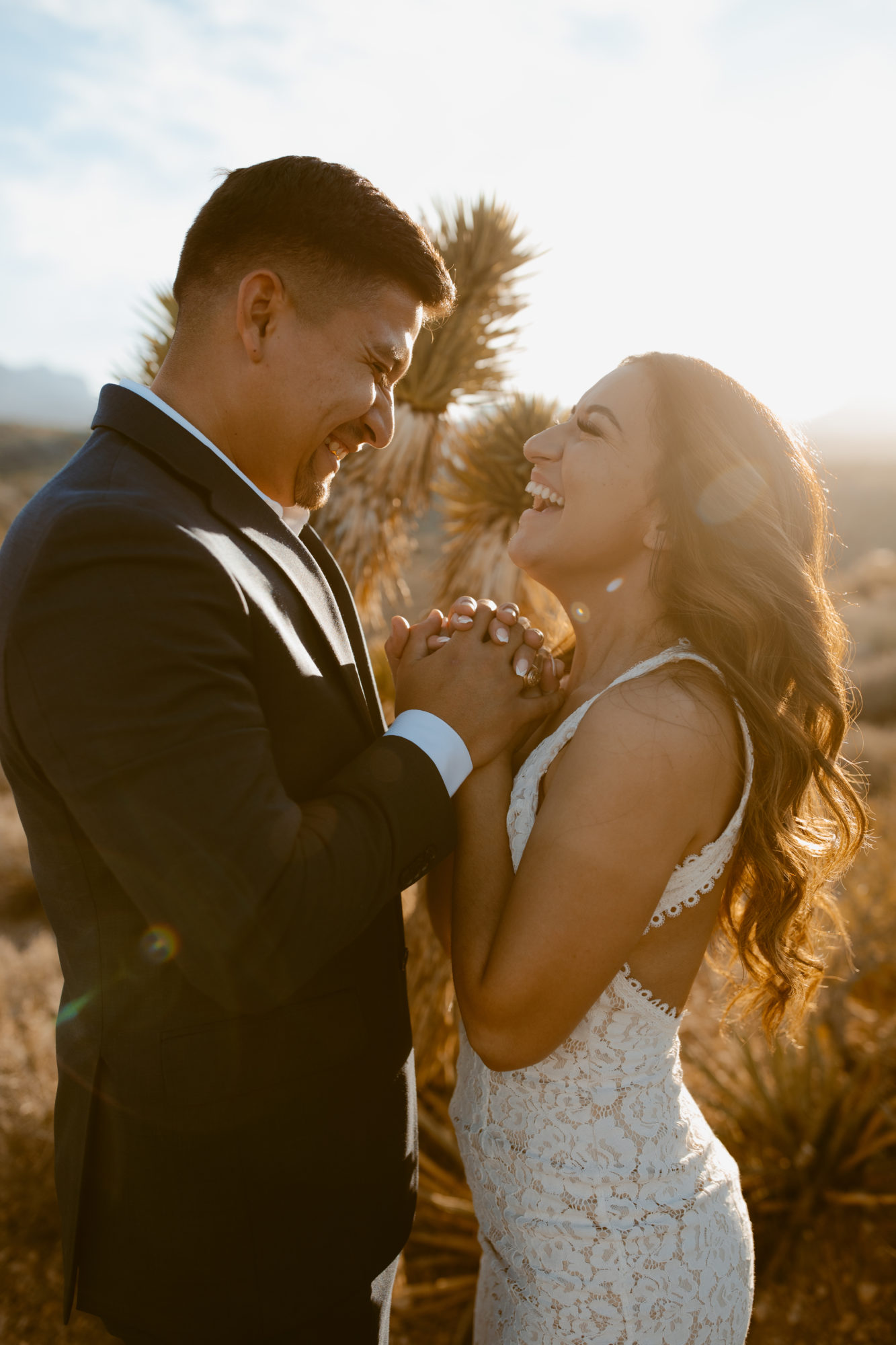 couple smiling at eachother during day after couples wedding photos in the desert 