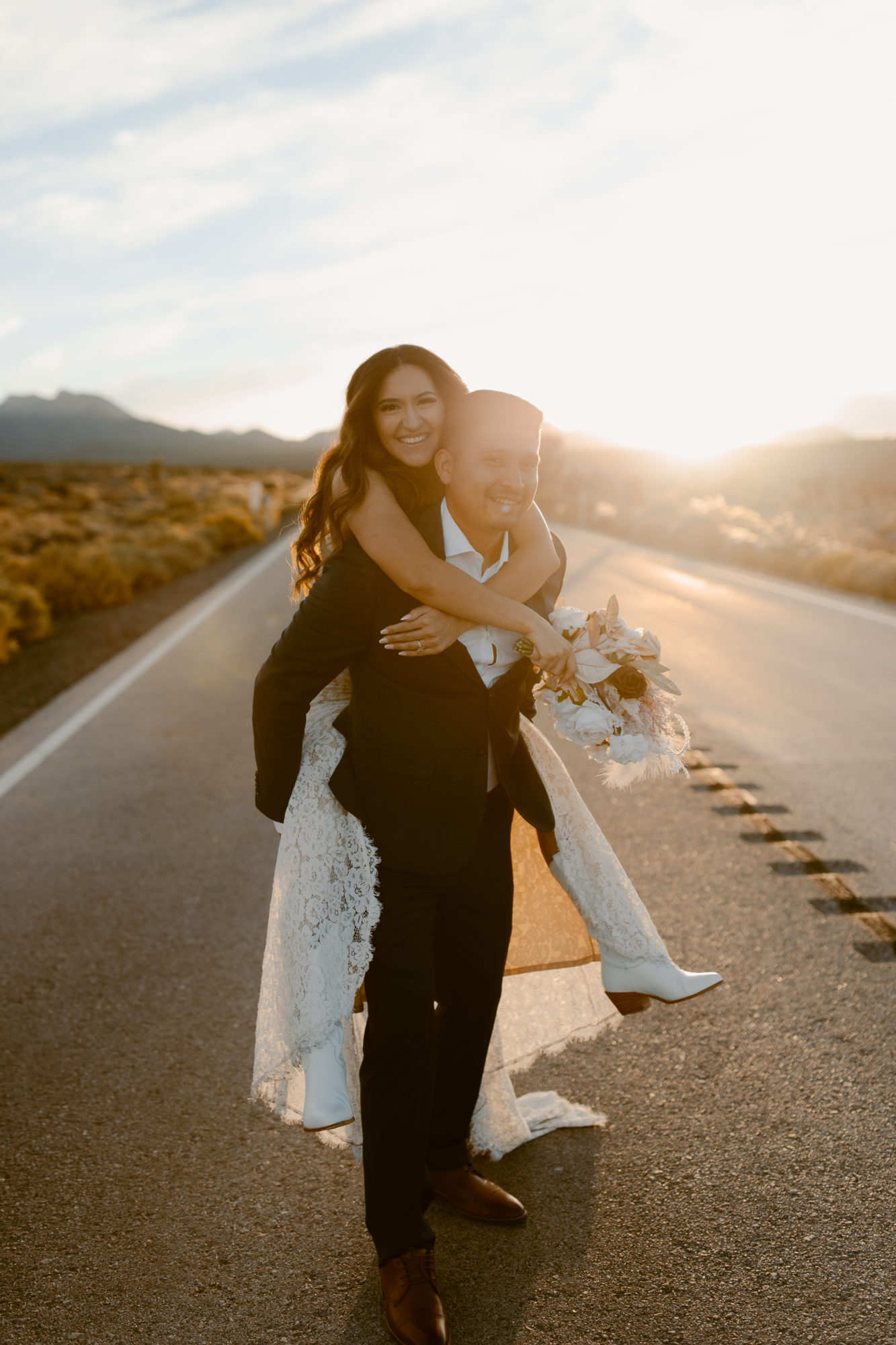 bride on grooms back during adventure day after photo session 