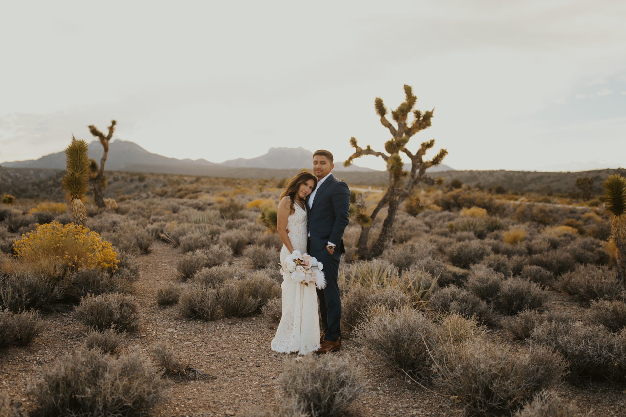 Bride and groom in the desert during  day after couples wedding photos