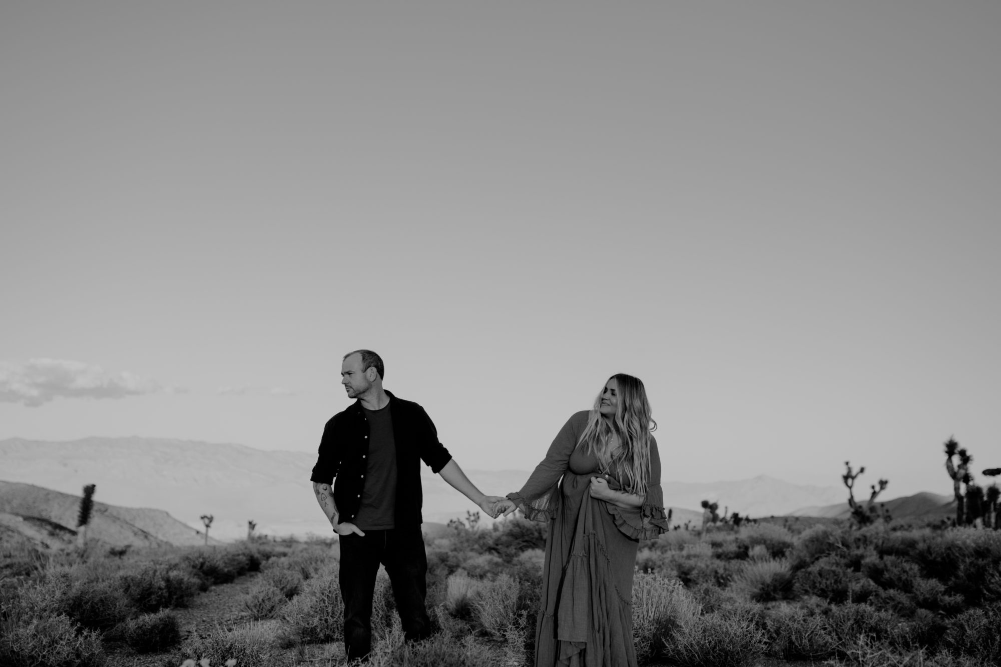 Man and woman posing for maternity photoshoot in the desert 